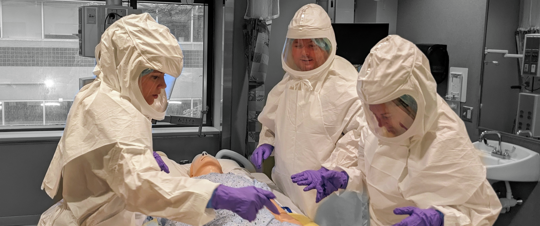 Medical staff simulate treating a patient with an extremely contagious illness during a biohazard training drill