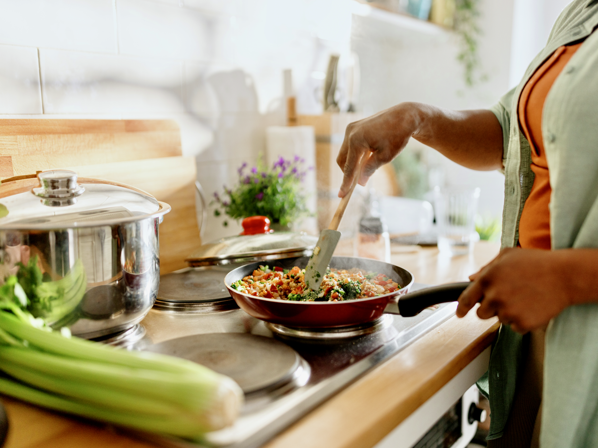 Woman cooking a colourful and nutritious quinoa stir-fry with mixed vegetables 