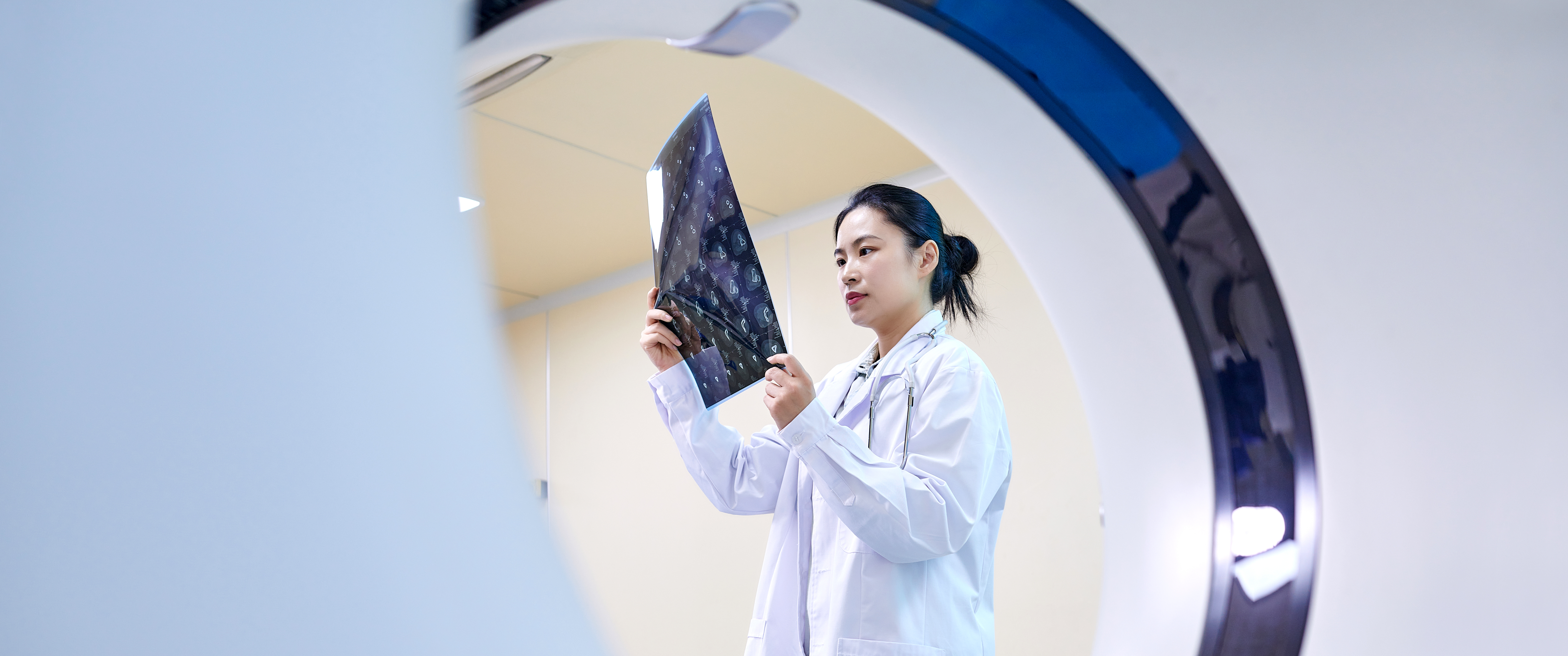 Doctor checking scan next to MRI machine