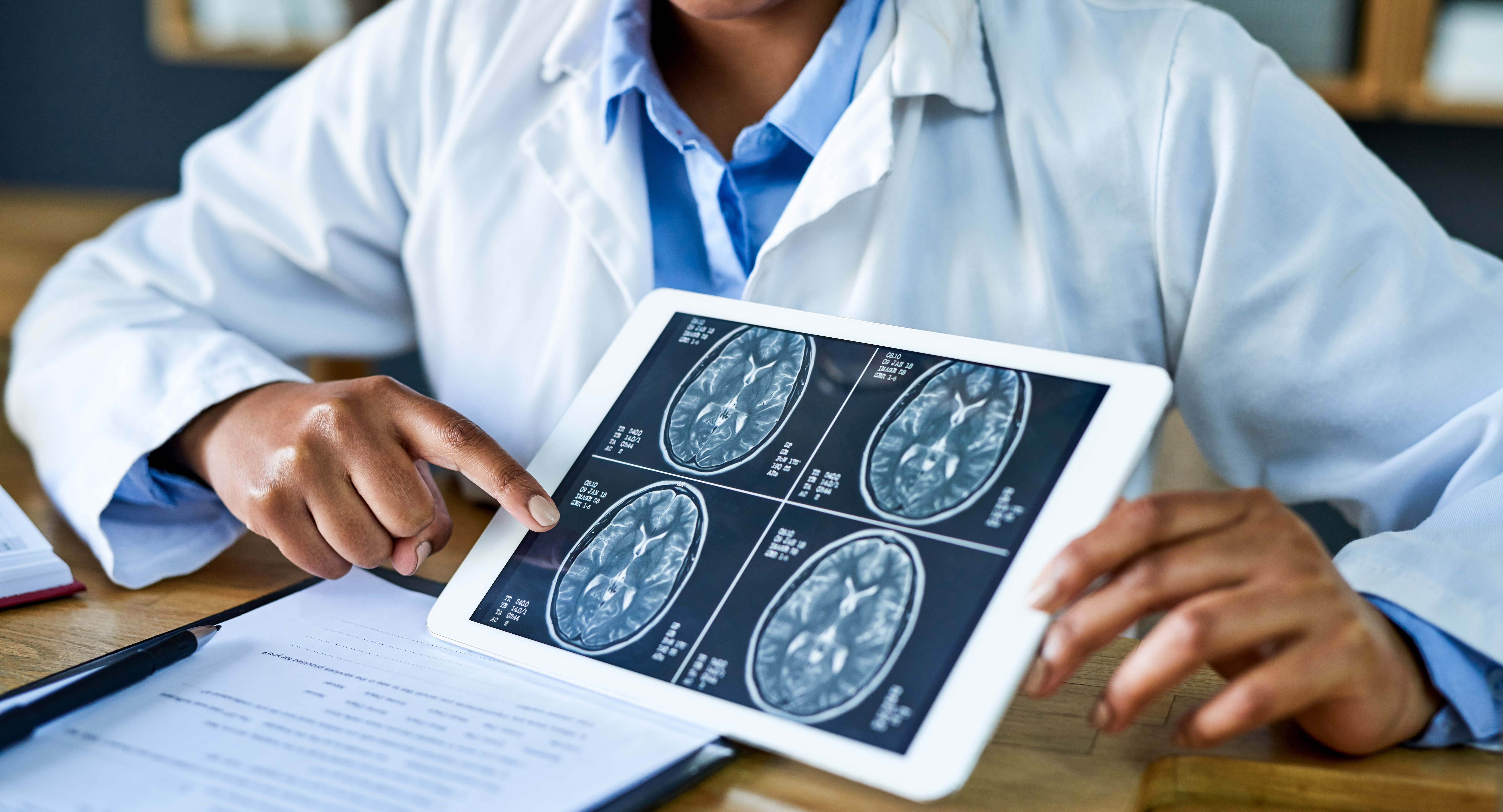 Doctor using a digital tablet to discuss a brain scan during a consultation in her office