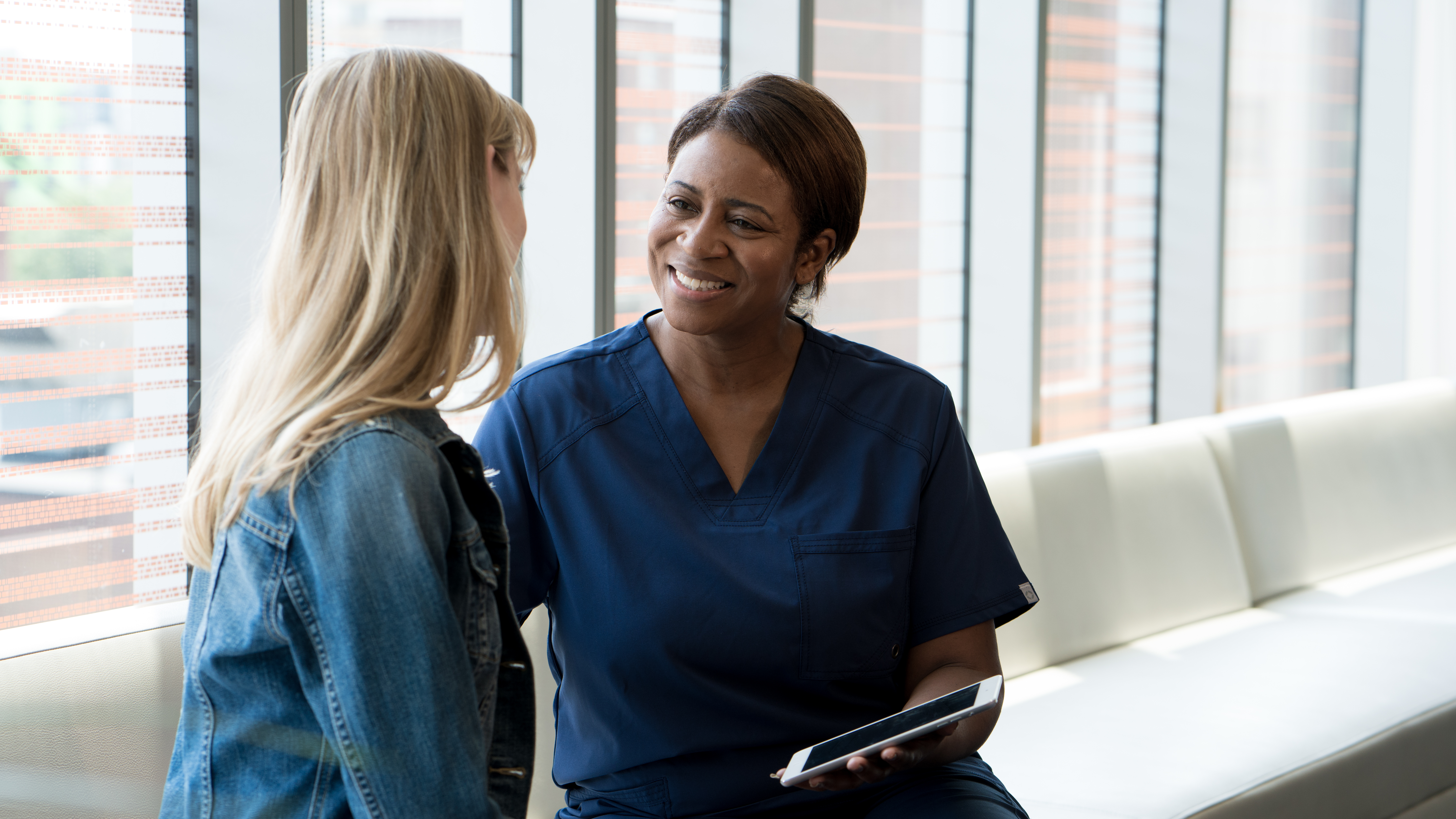 Primary care nurse sitting with patient