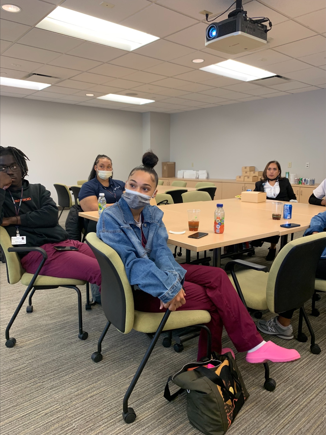Amber Marie DeLoatch sits in a classroom with other employees.