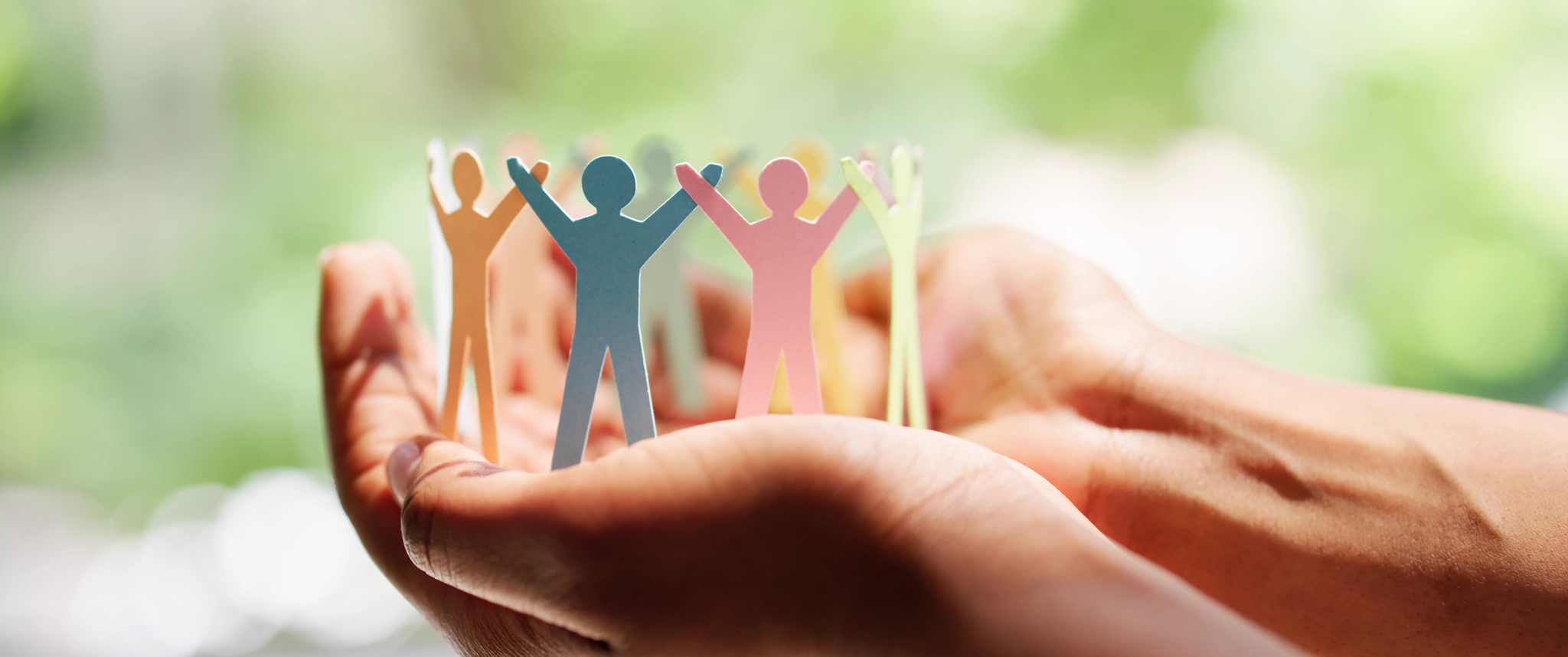 A person holding a paper chain of people