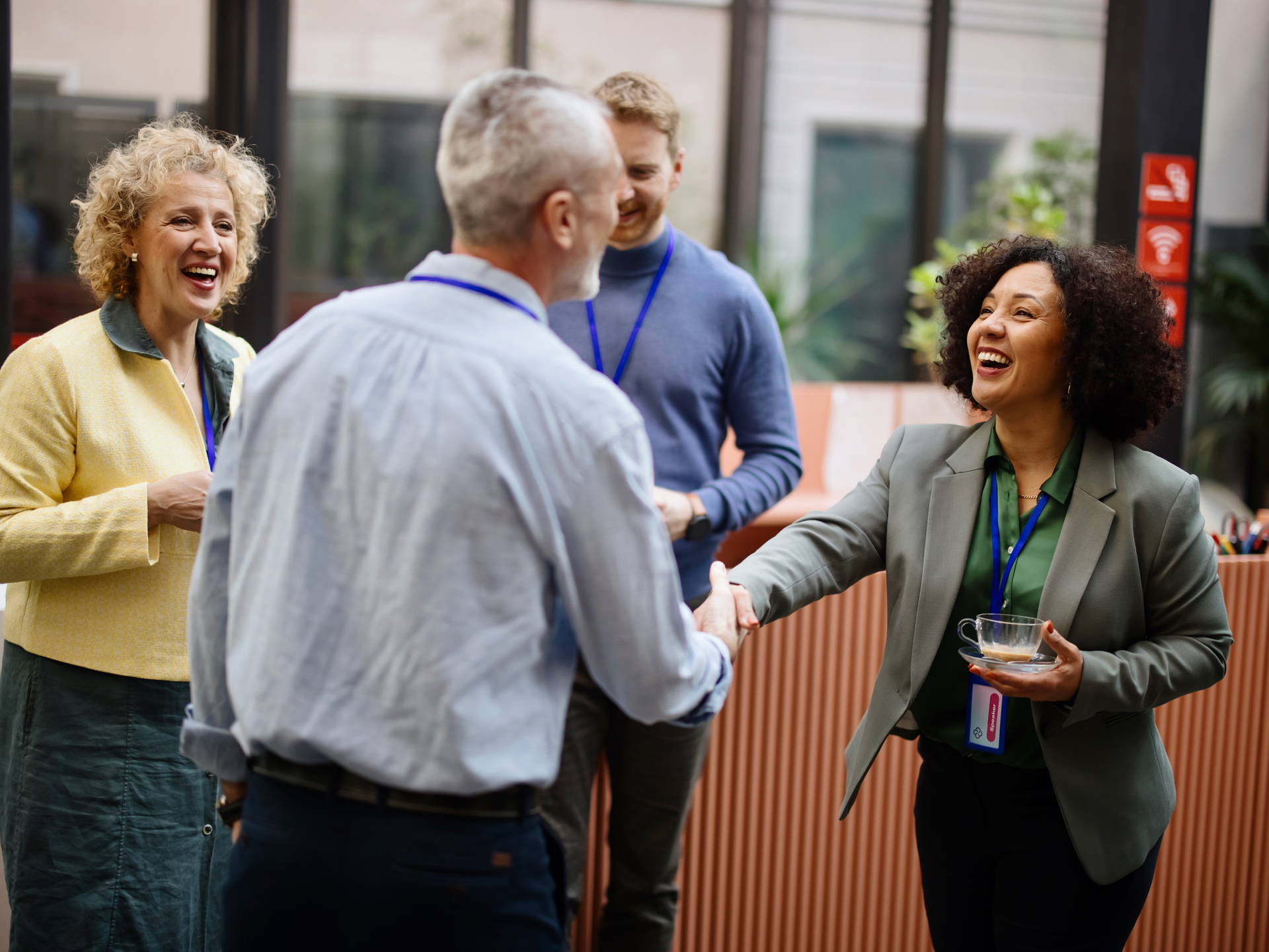 Business people greet each other during a coffee break at a conference