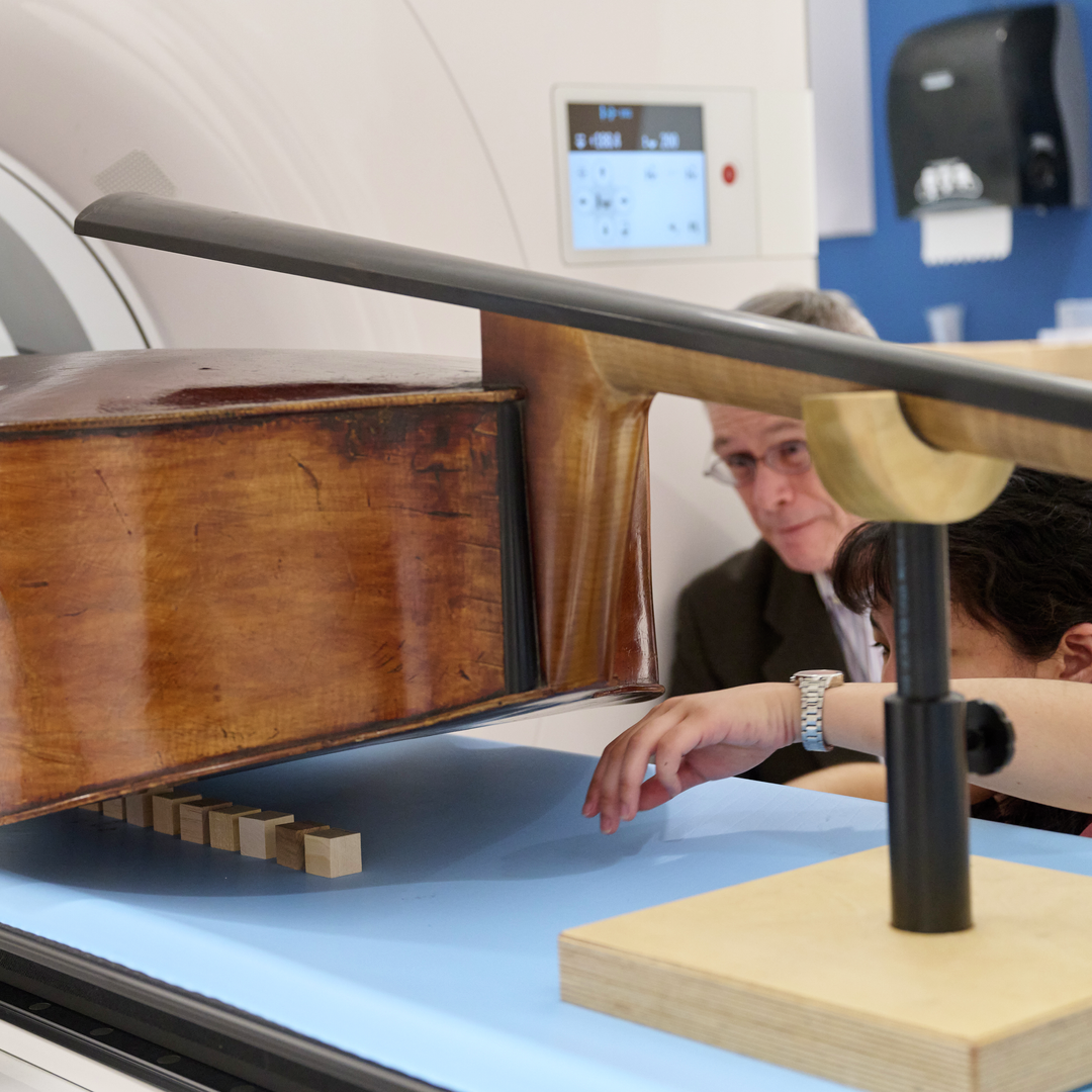 Mark Kindig and Leening Liu adjust the position of a double bass to prepare it for a CT scan