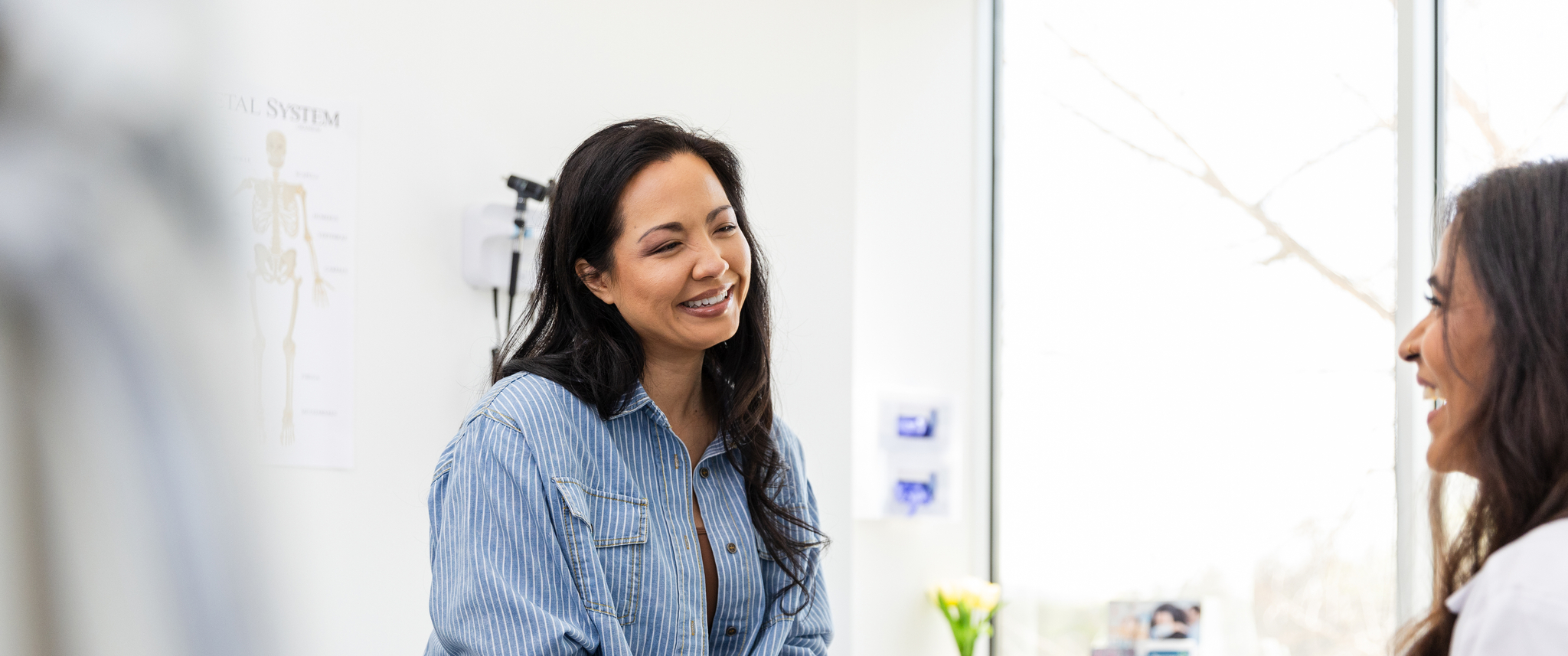 Patient and doctor laughing in exam room during appointment