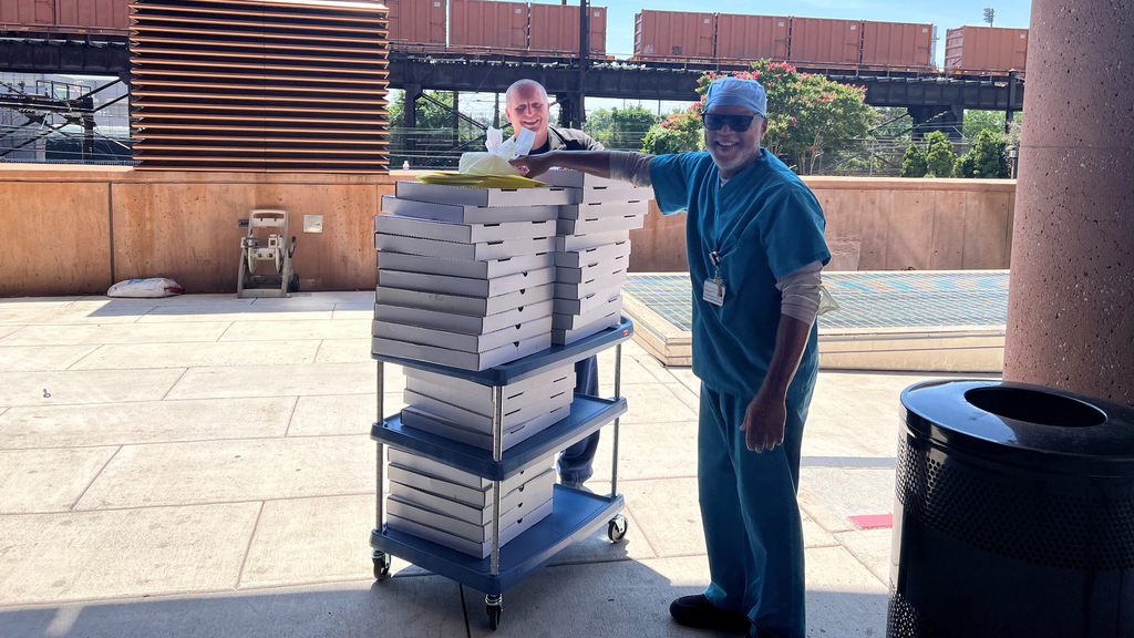 Phil Gaspari, director of Operations for Emergency Medicine, left, with Darrell Harris, a medical equipment supply manager, stand by a cart stacked with pizzas for the Hospital of the University of Pennsylvania's Emergency Department