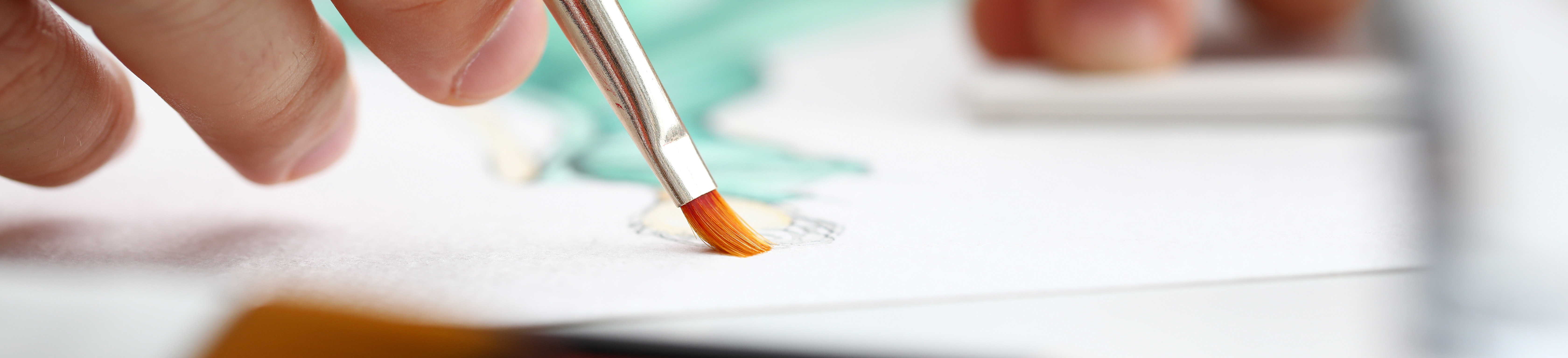 Male hand painting with thin paint brush