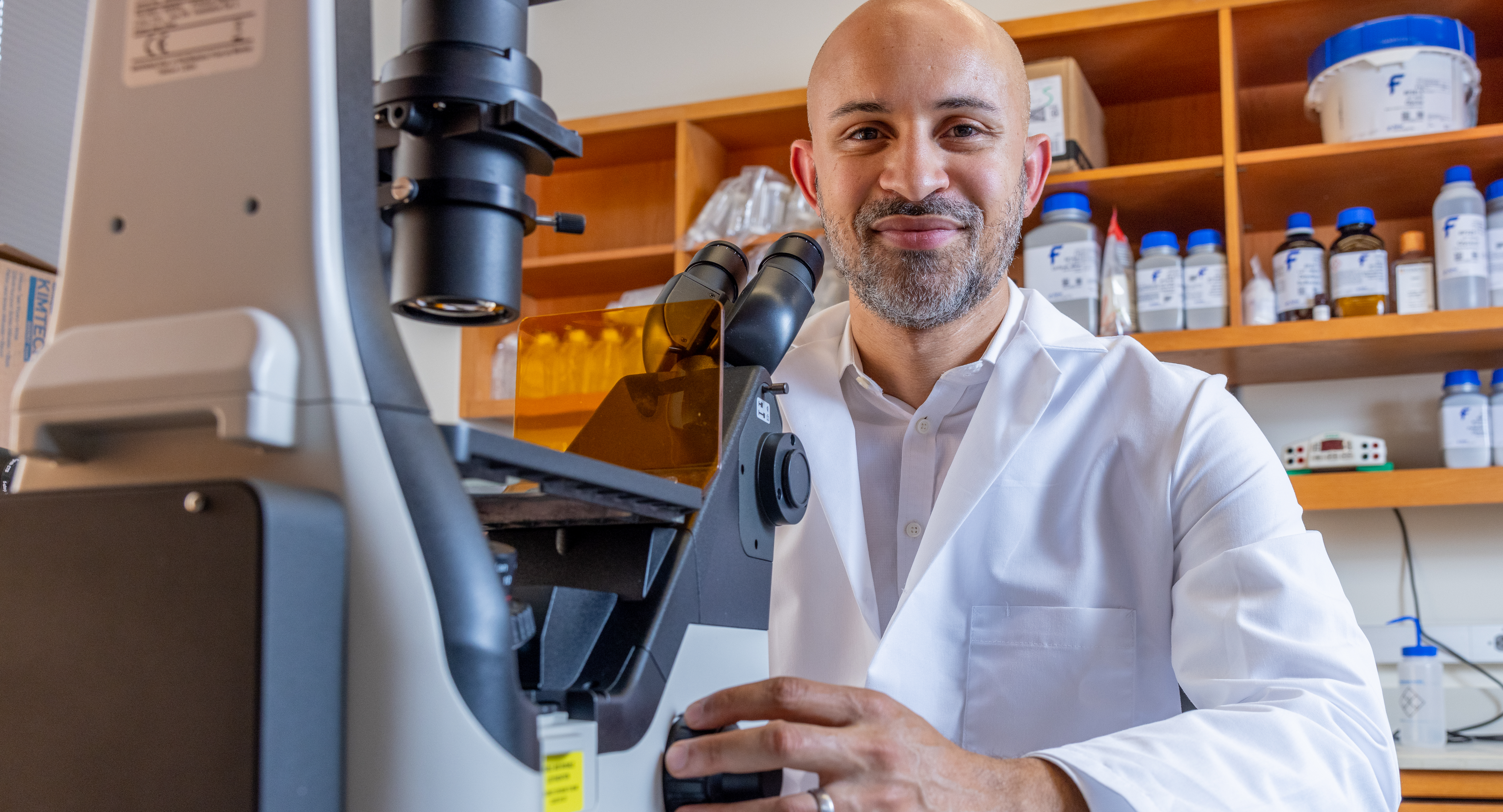 Richard Edmund Phillips, MD, PhD, at microcope in brain cancer research lab