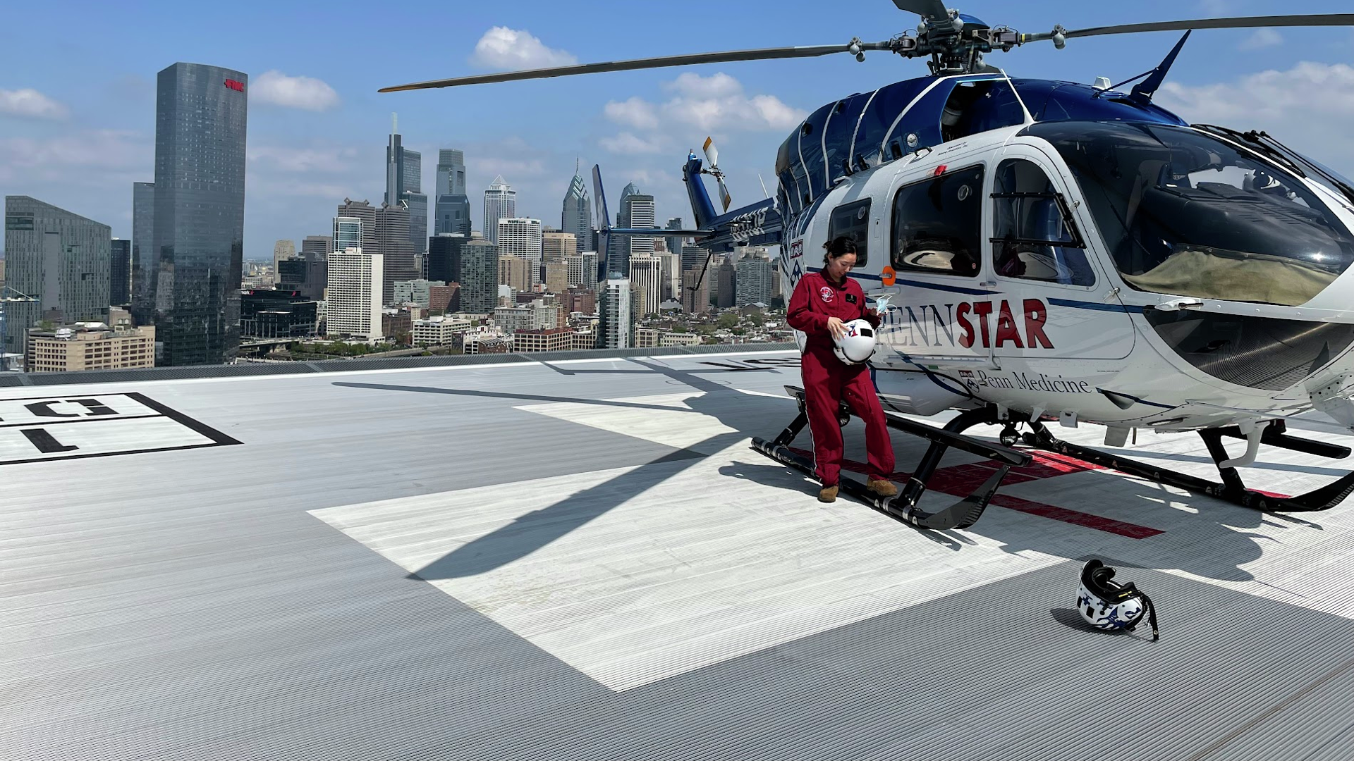 Hyun Kyoung Na standing on a helipad next to the PennSTAR helicopter