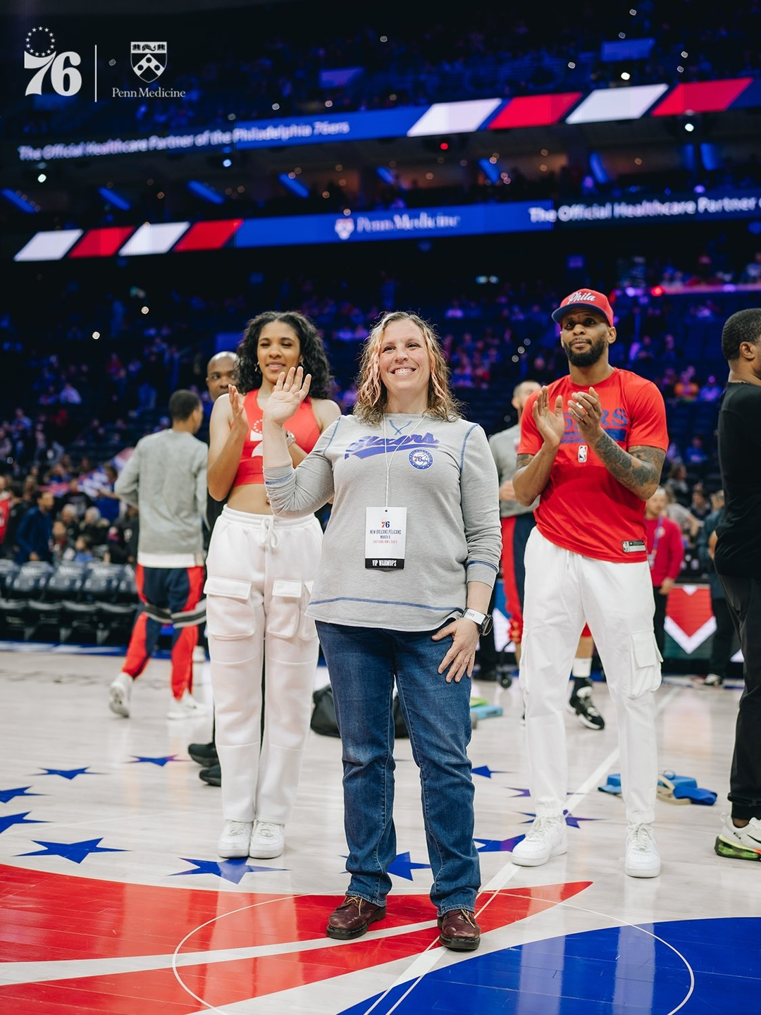 Sunny Jackson waves at the crowd from the court at a Philadelphia 76ers game