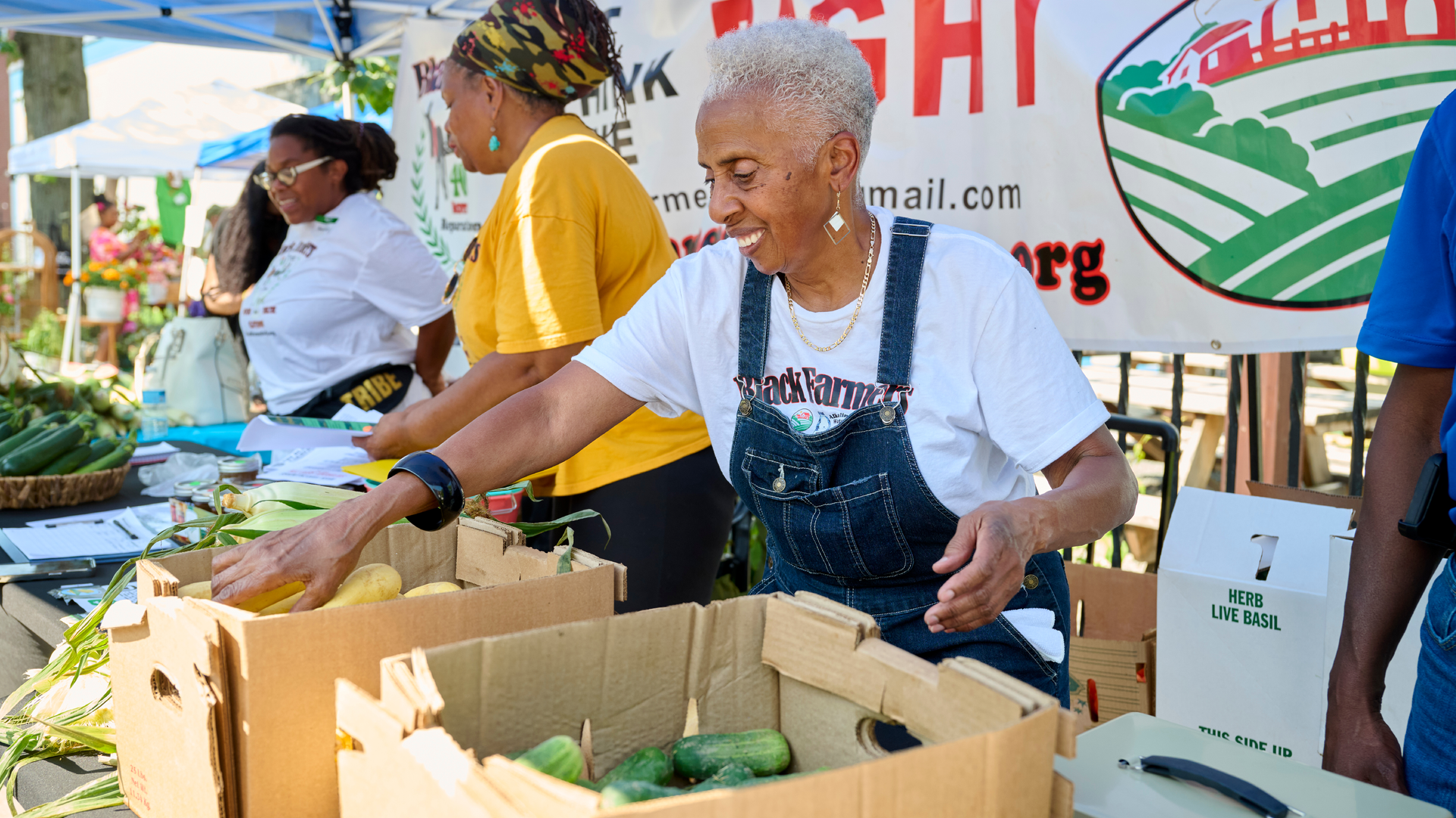 Carol Simmons at the Black Farmers Market at a stand selling produce with other volunteers