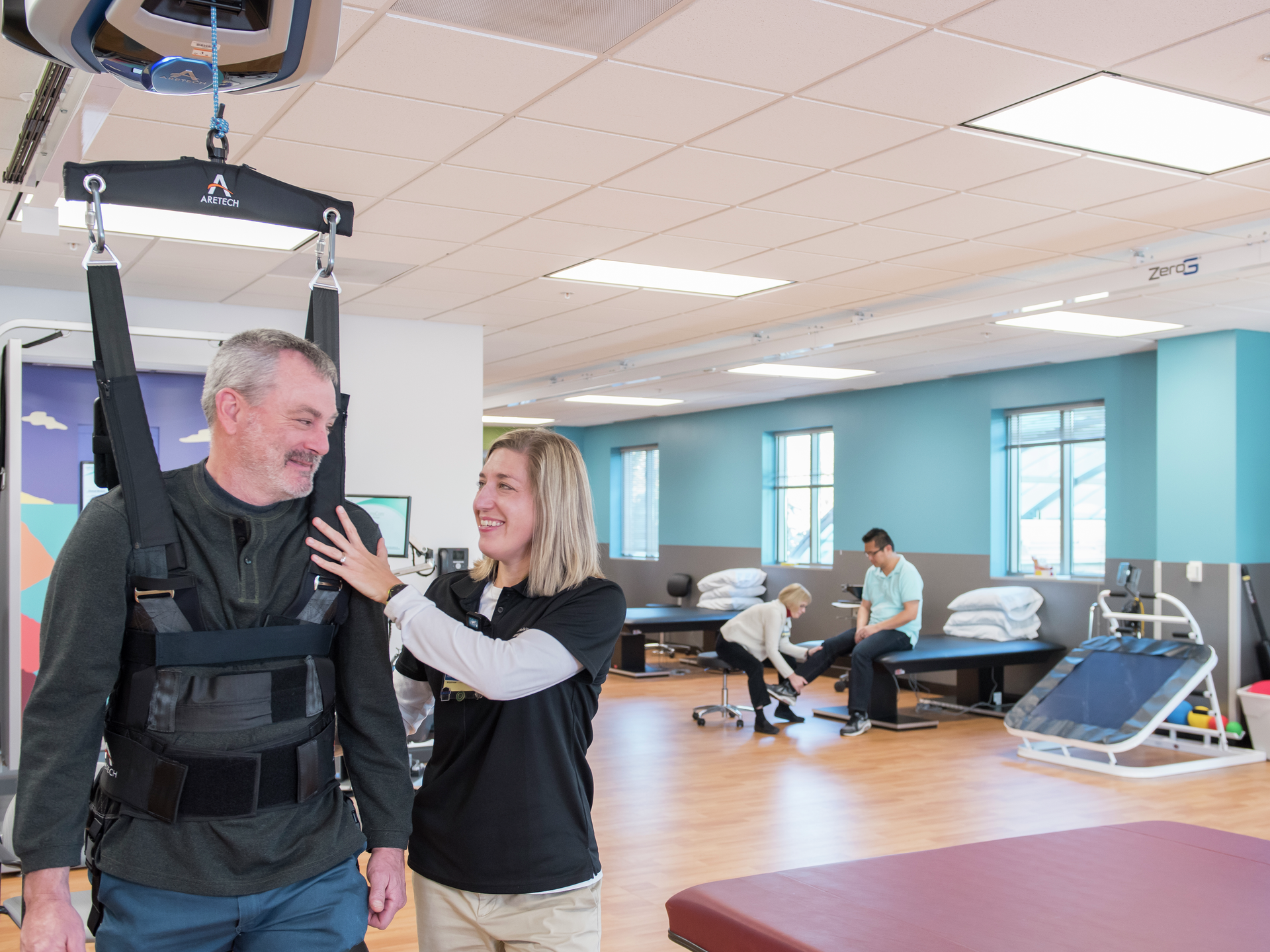 Physical therapist helping patient walk in zero gravity harness at the LGH Neuroscience Institute