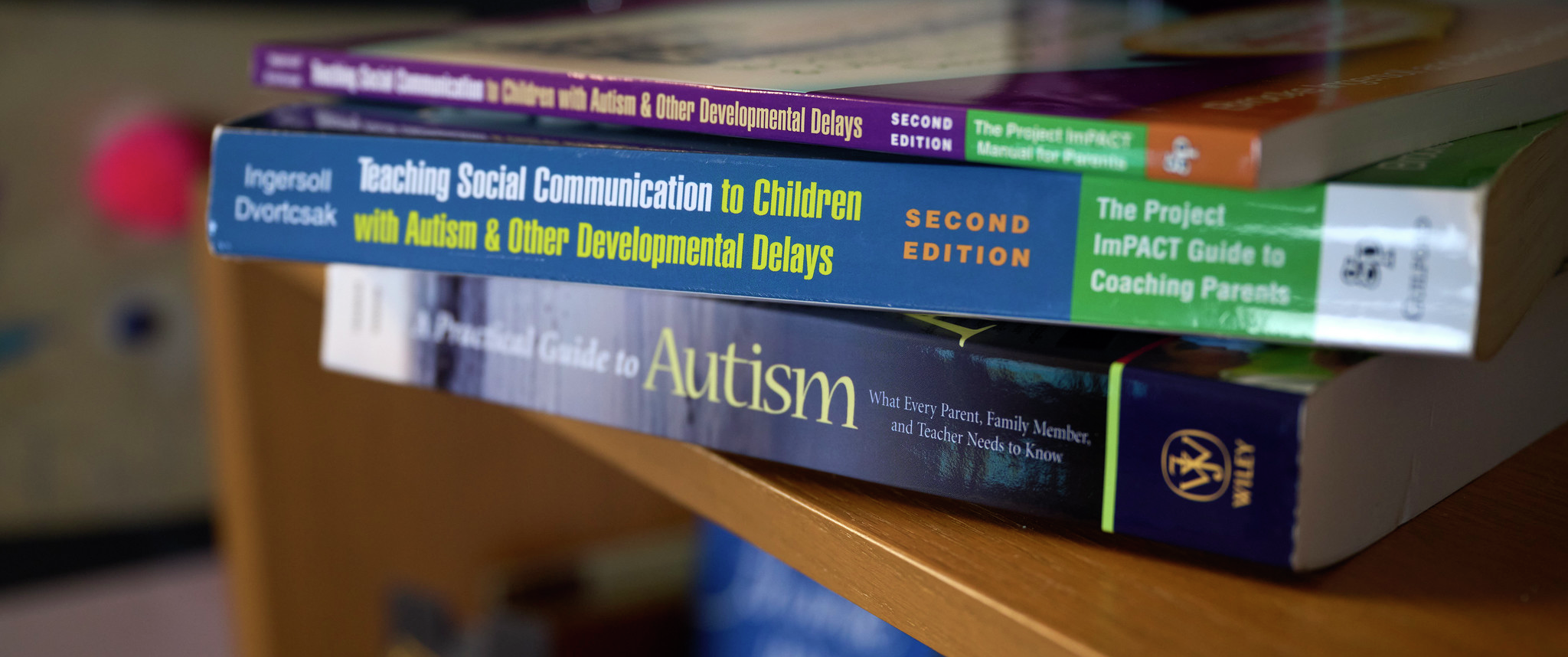 A stack of books, all on the subject of helping parents communicate with children with autism