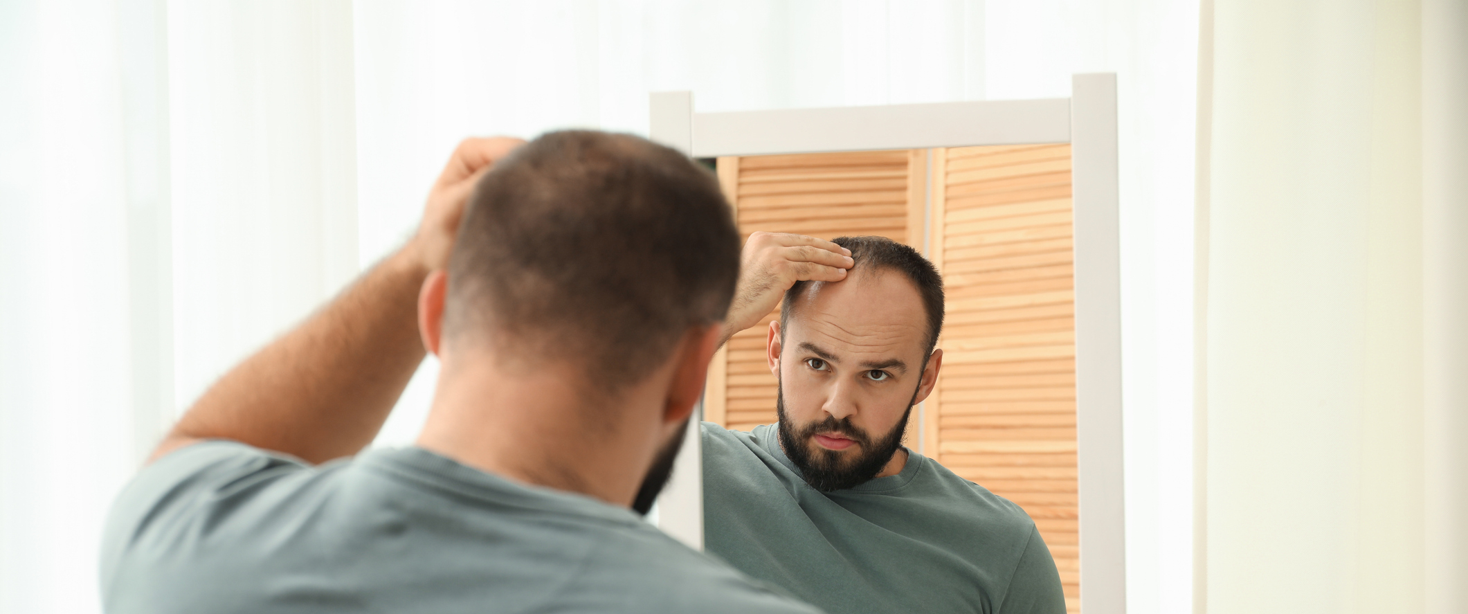 A man checking for hair loss in a mirror