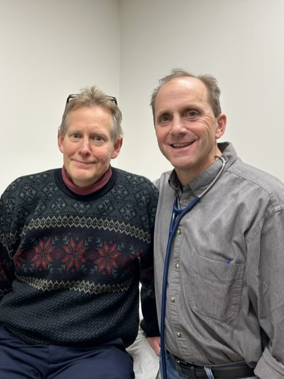 Bill Curtis standing next to James Todd Alderfer in a doctor's office