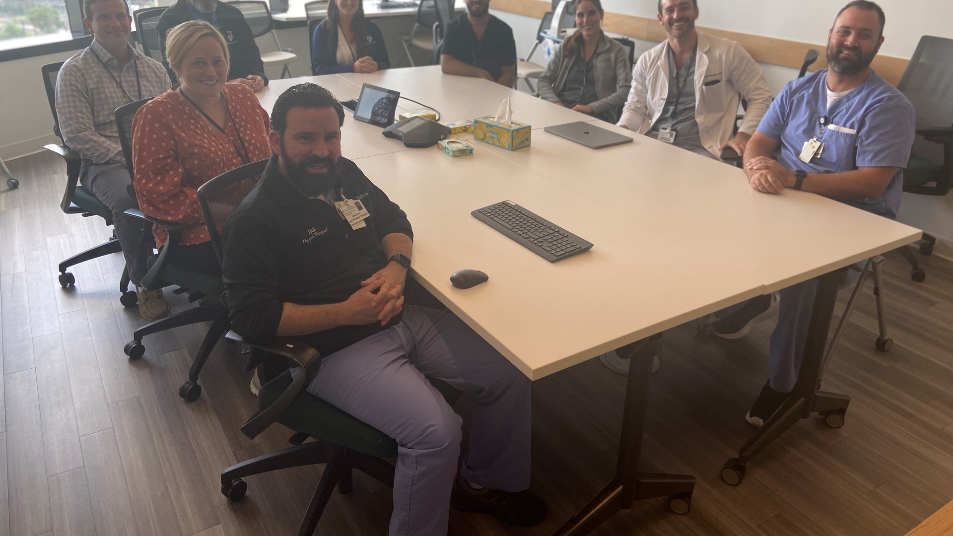 Several members of the RECOVER team sit at a conference table