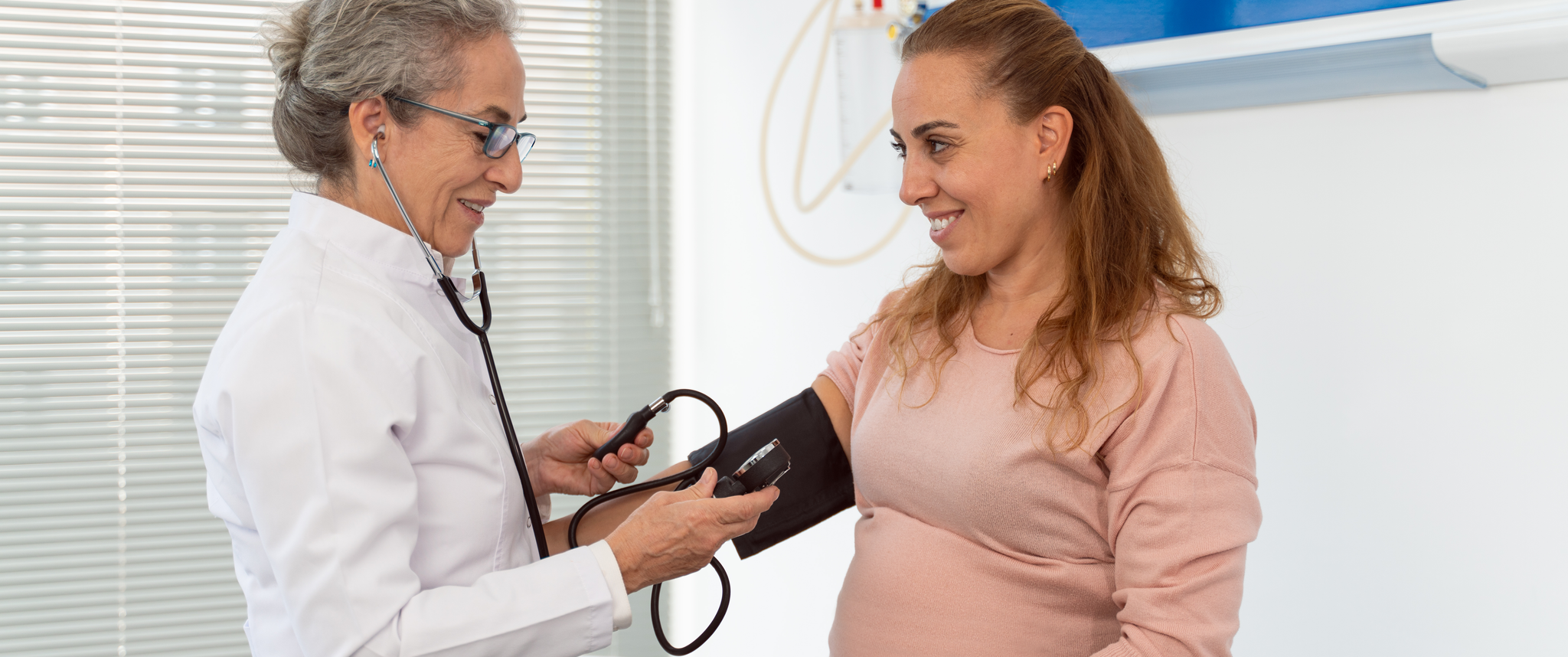 A doctor measures the blood pressure of a pregnant woman