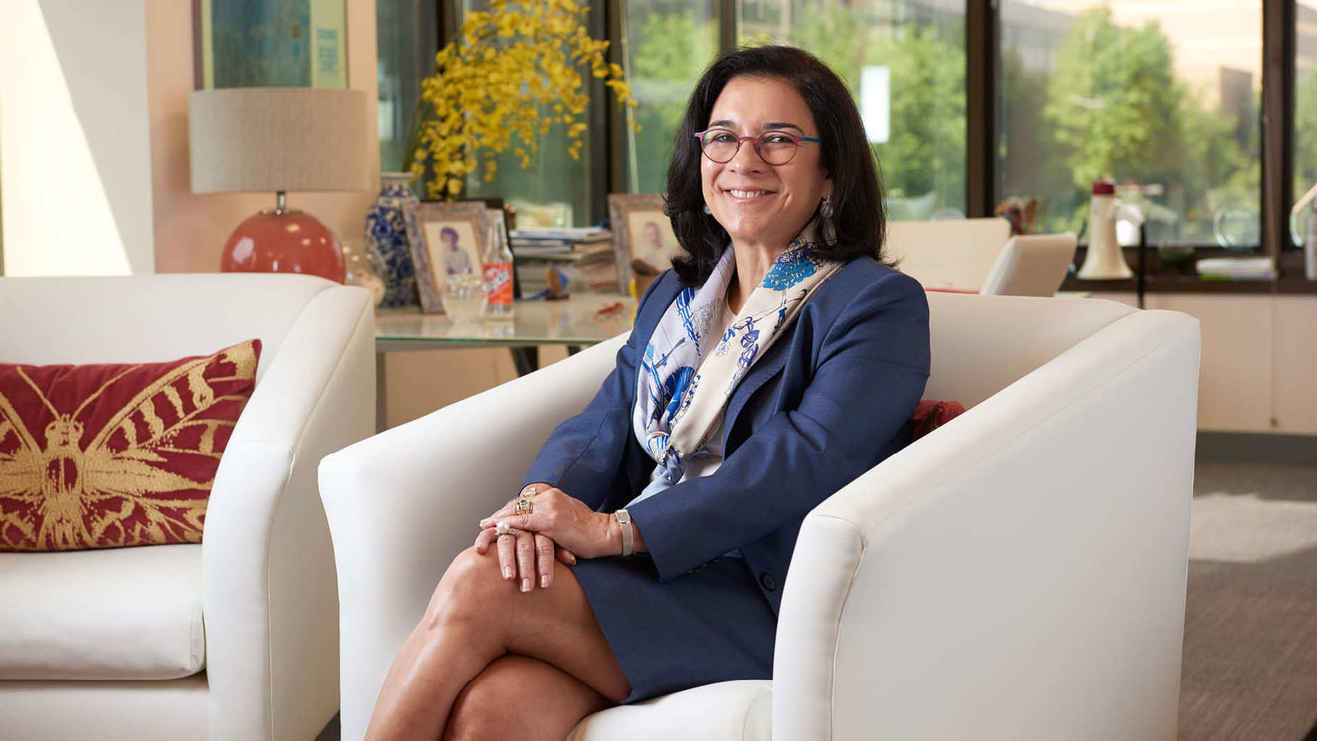 Maria Oquendo seated in an armchair smiles with a calm expression 