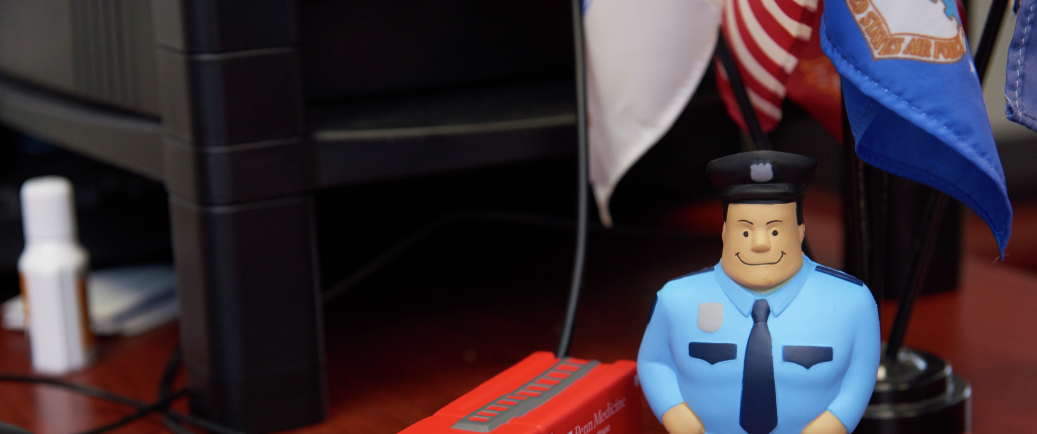 Toy items on a desk signify first responders: A police officer and a fire truck branded with Princeton House Behavioral Health information