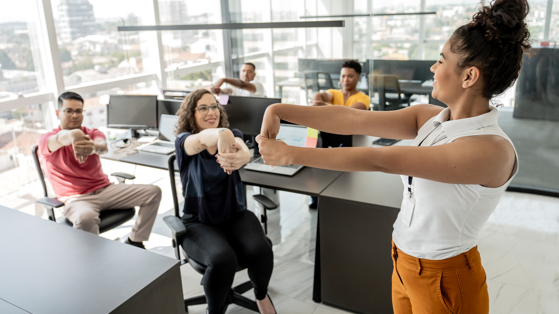 Workers doing stretching exercises before work in a telemarketing office