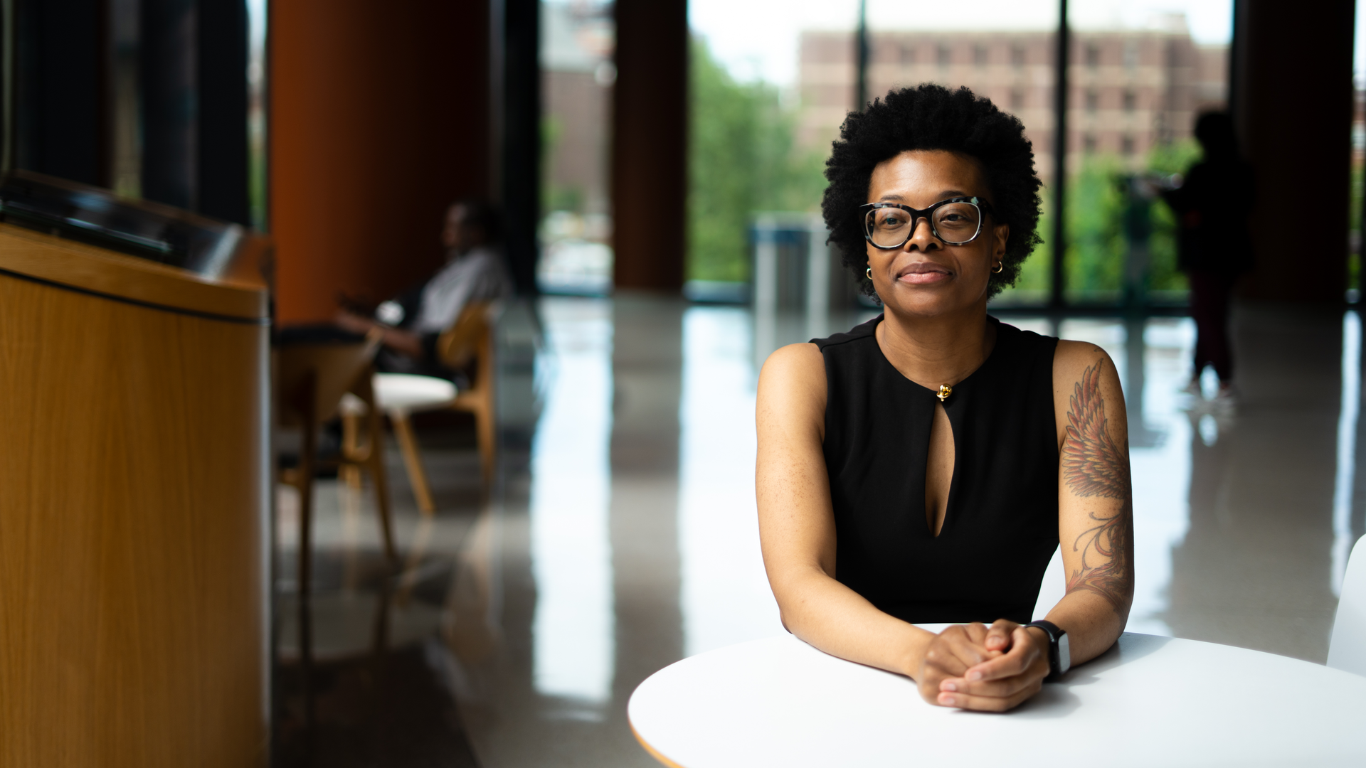 Dovie Watson, MD, looks thoughtful while seated at a table with her hands clasped