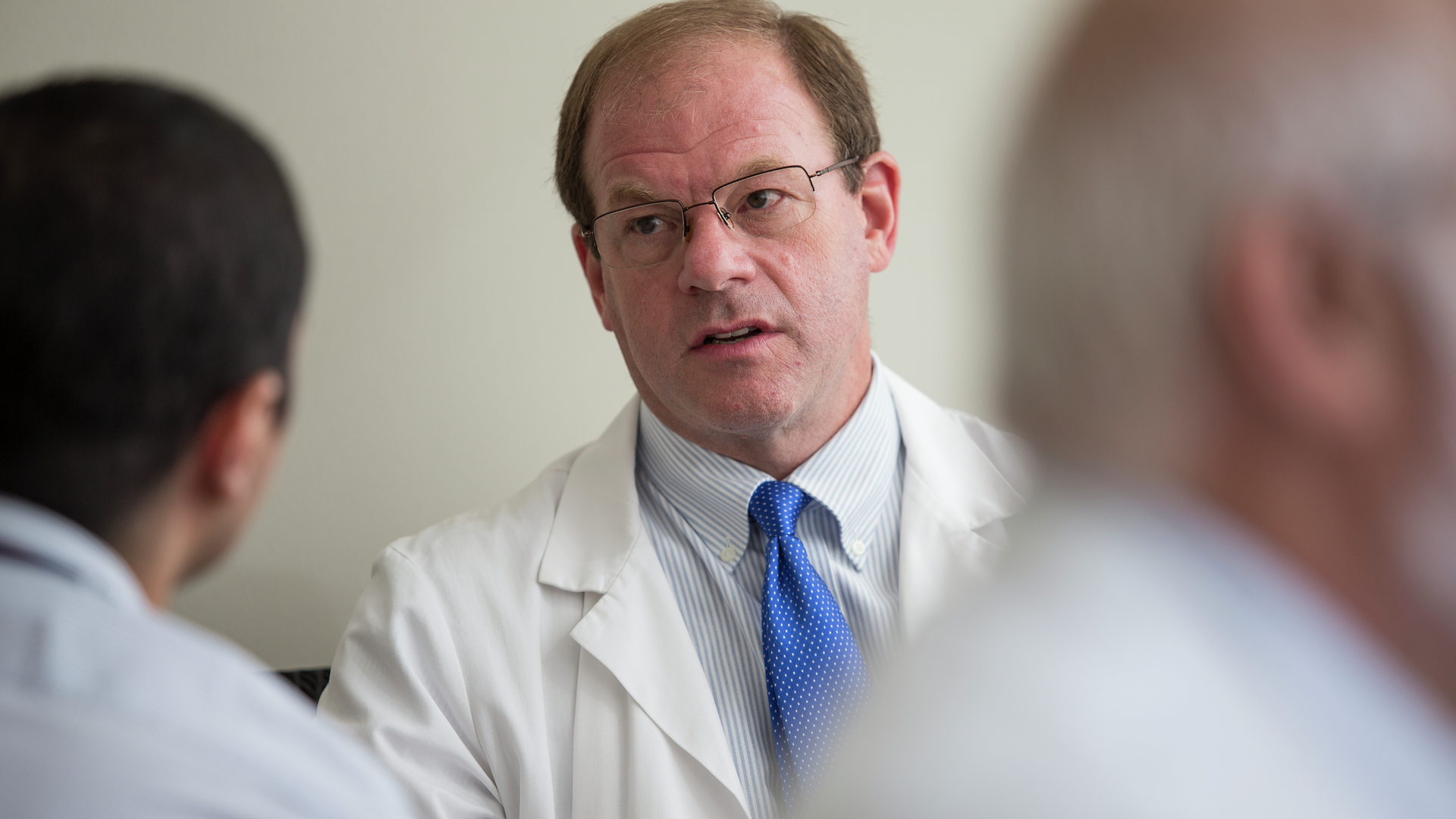 Closeup of doctor, Brian Litt, talking with colleagues