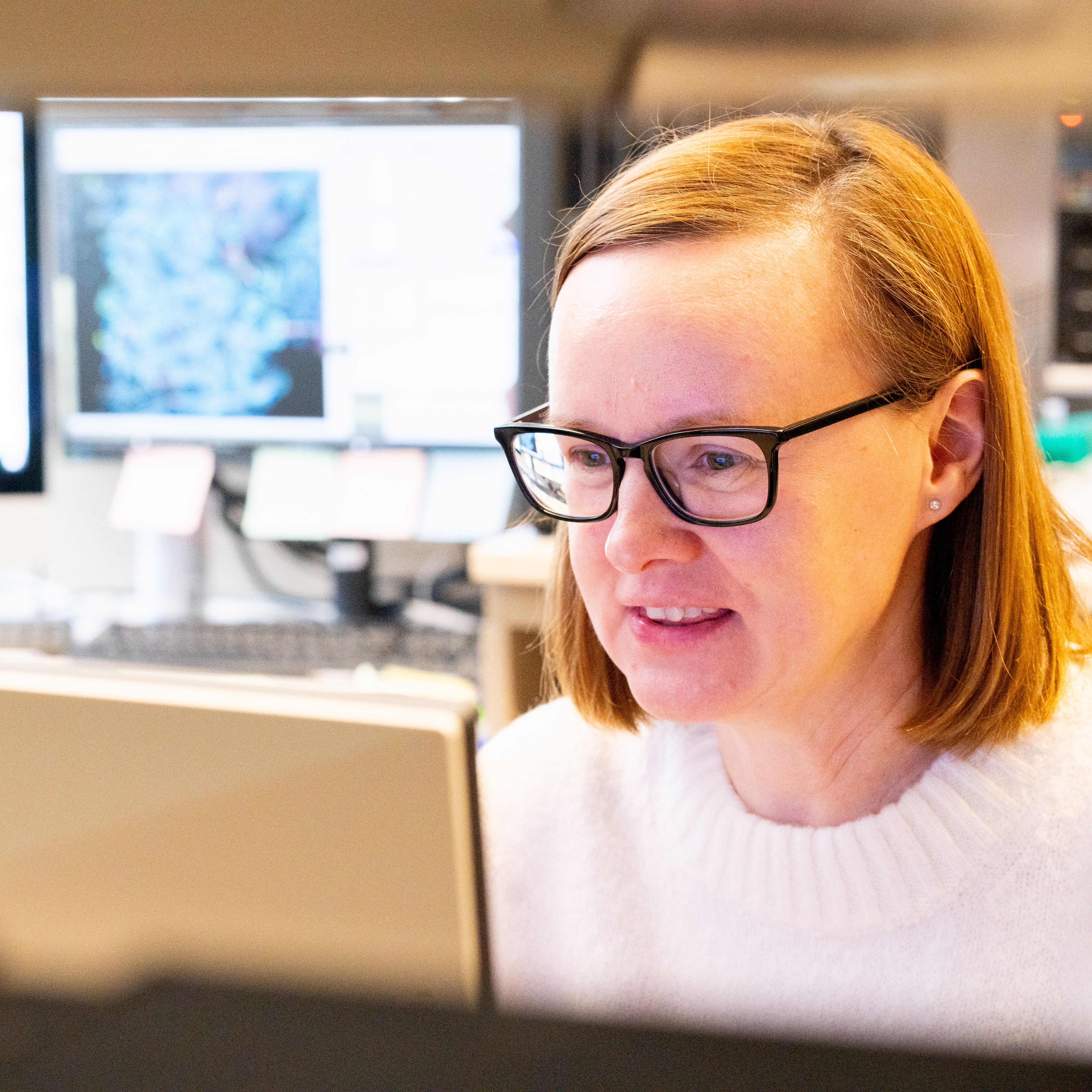 Julia Rocerata and Vera Moiseenkova-Bell look together at images on a computer screen, smiling