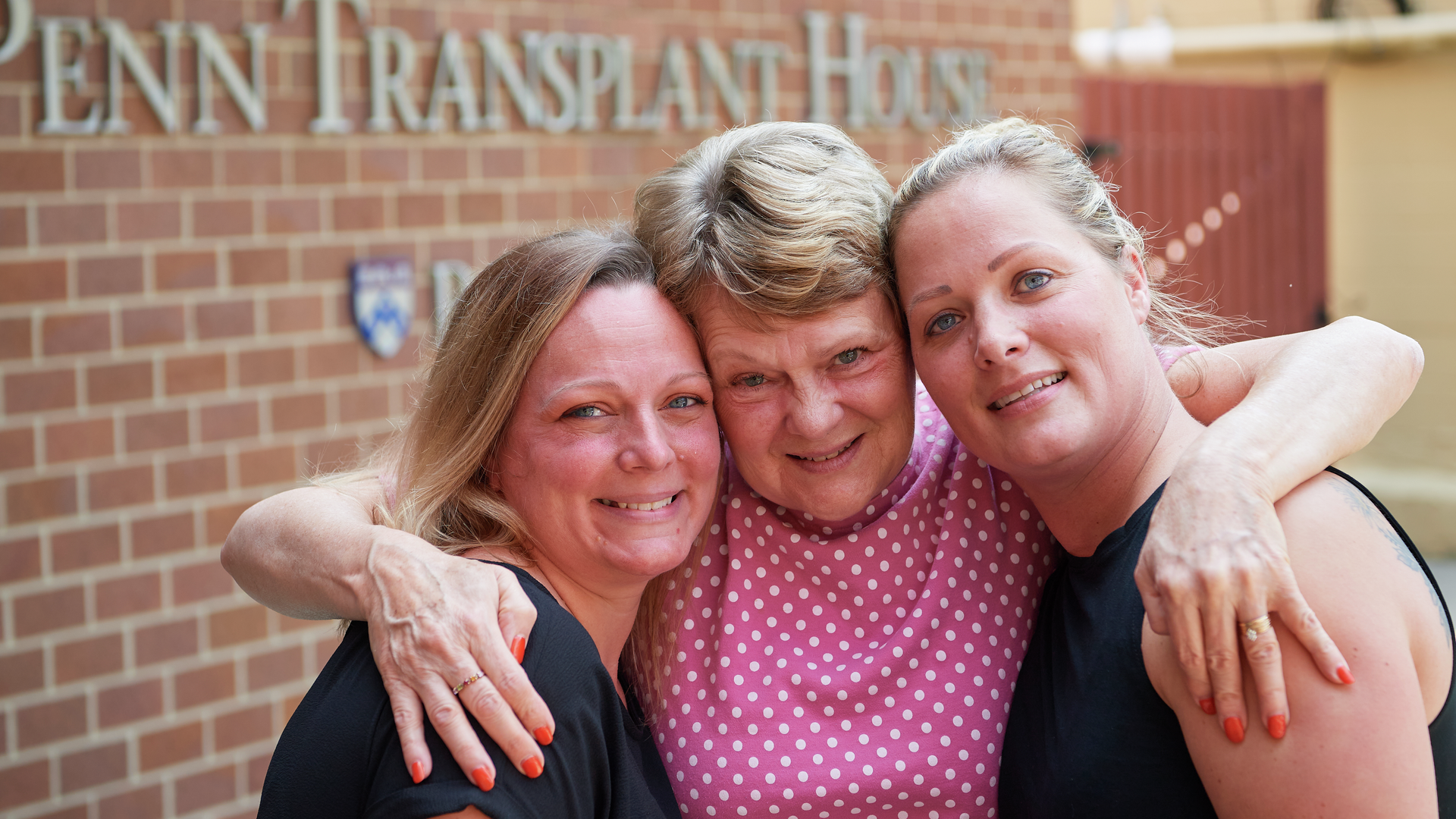 Penn Transplant patient and family embracing outside the Clyde F. Barker Penn Transplant House
