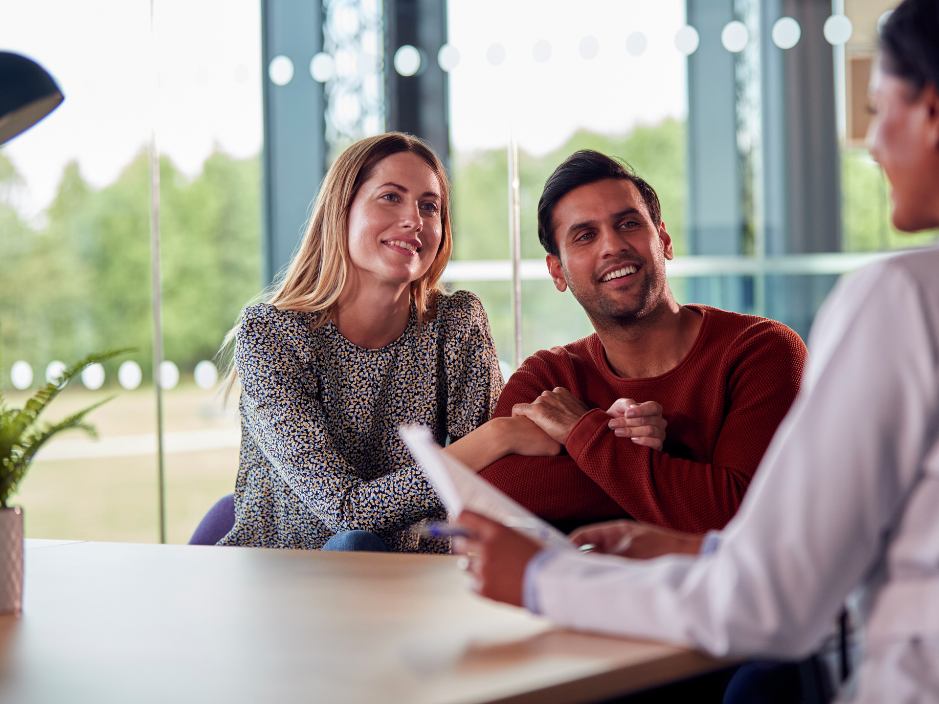 Doctor discussing test results with smiling couple in hospital
