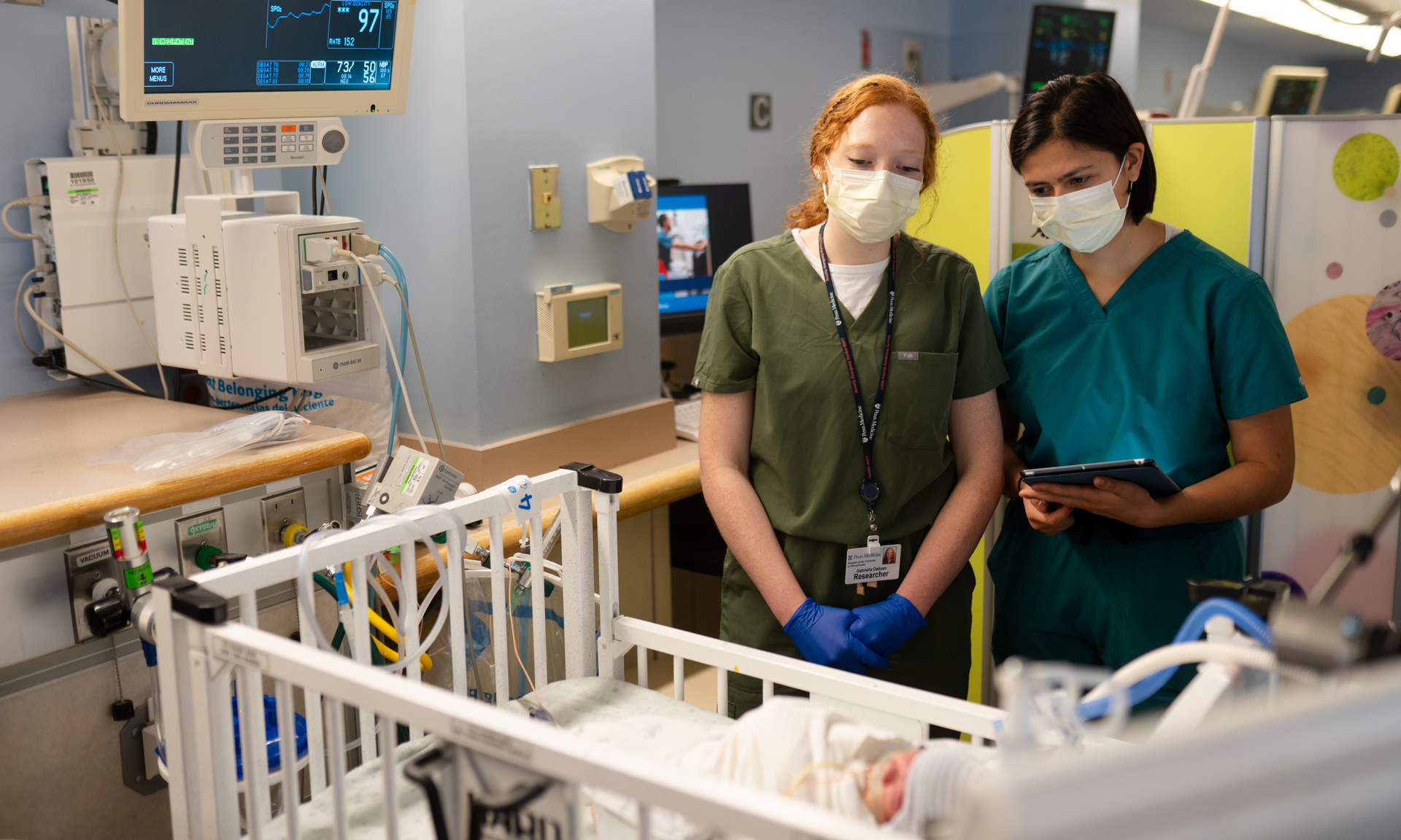 Gabby Daltoso and Sophie Ishiwari testing the Sonura Beanie on a baby in the Intensive Care Nursery