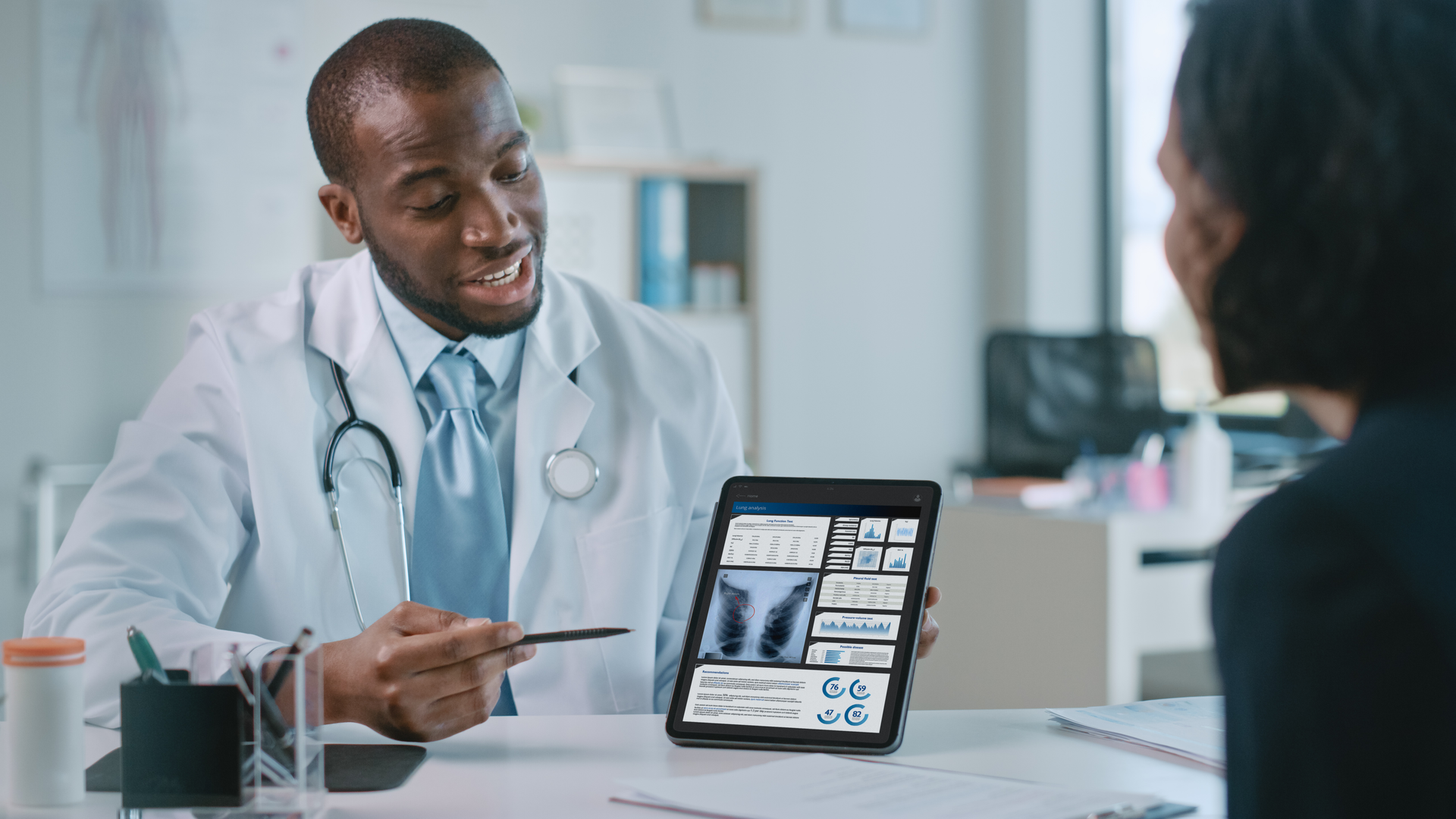 Female patient listens to pulmonologist explain lung analysis results on tablet