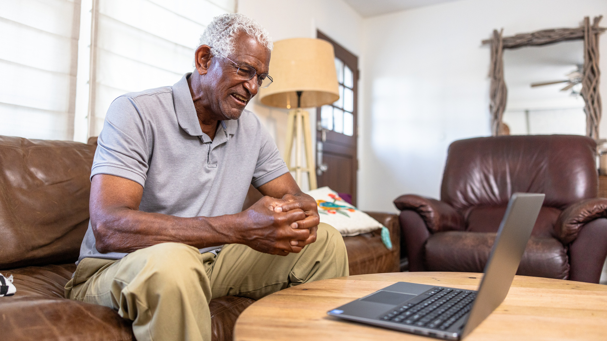 Senior black man attending a webinar on laptop computer.