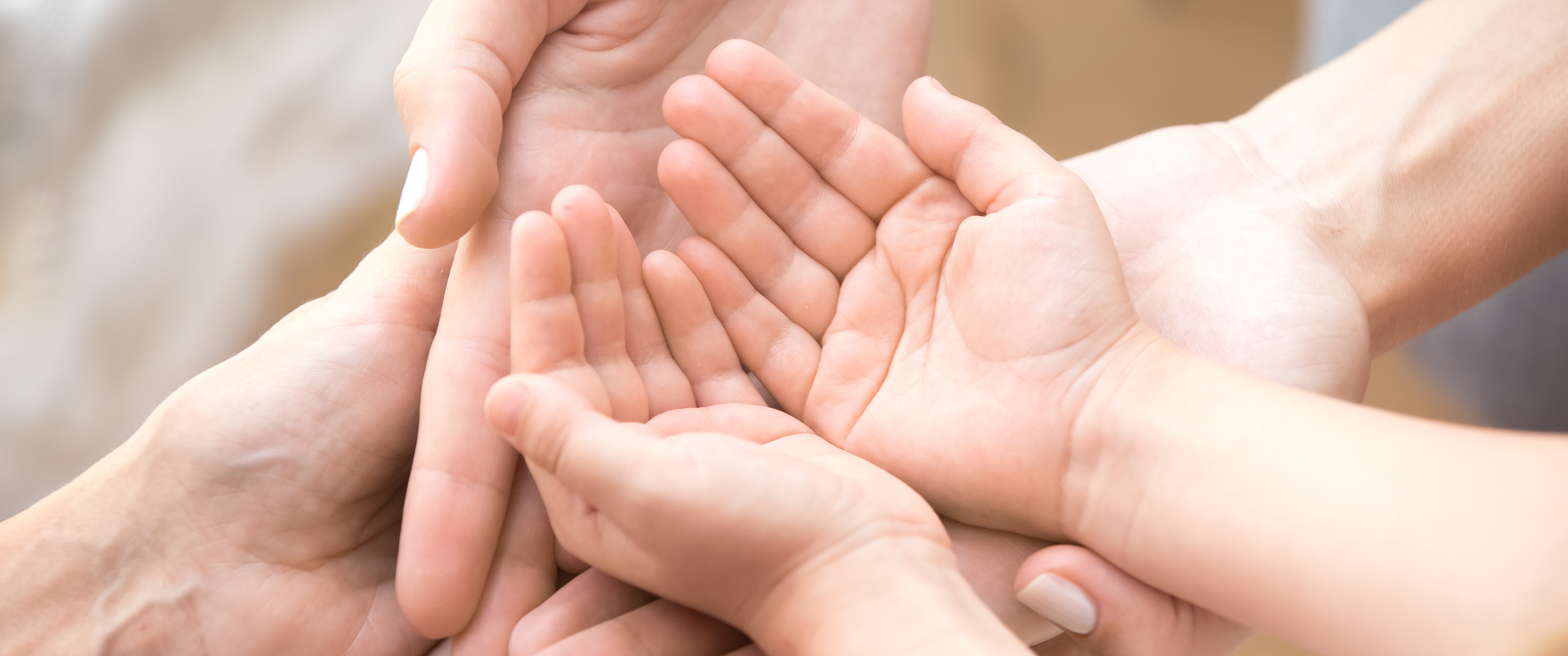 Close-up of three people stacking their palms