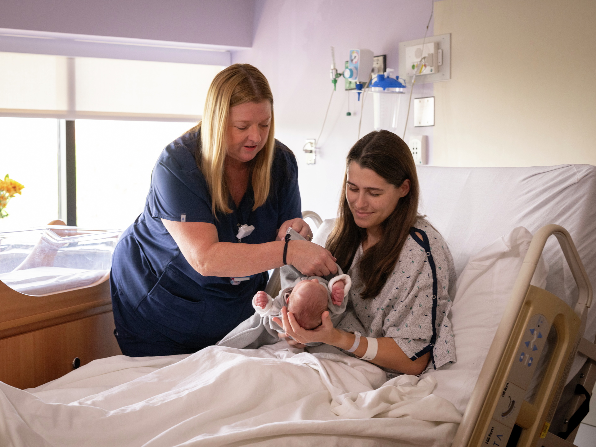 Nurse helping a new mother and her baby at the Labor and Delivery section of the Maternity