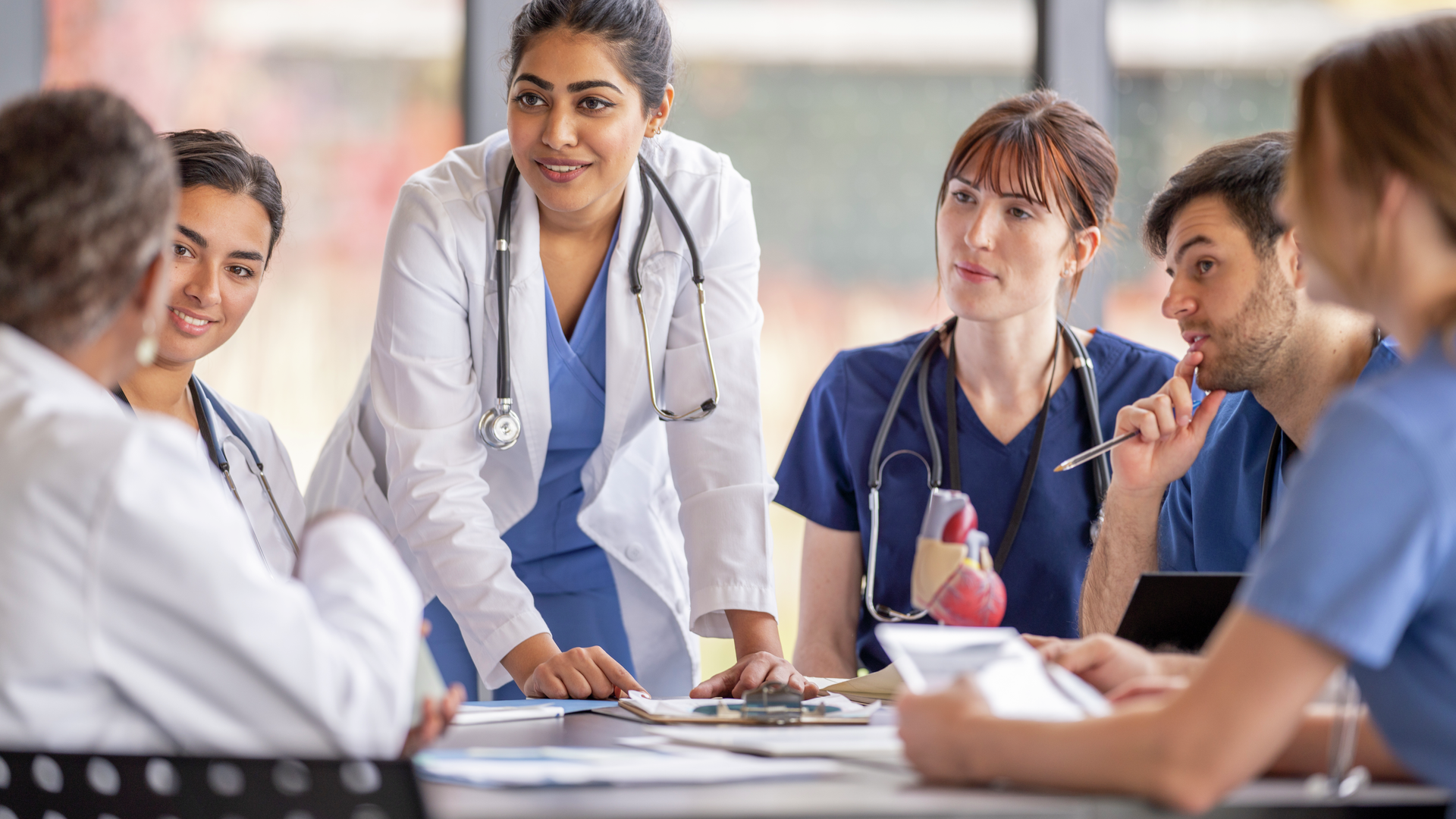 Medical professionals discussing idea around table in meeting room