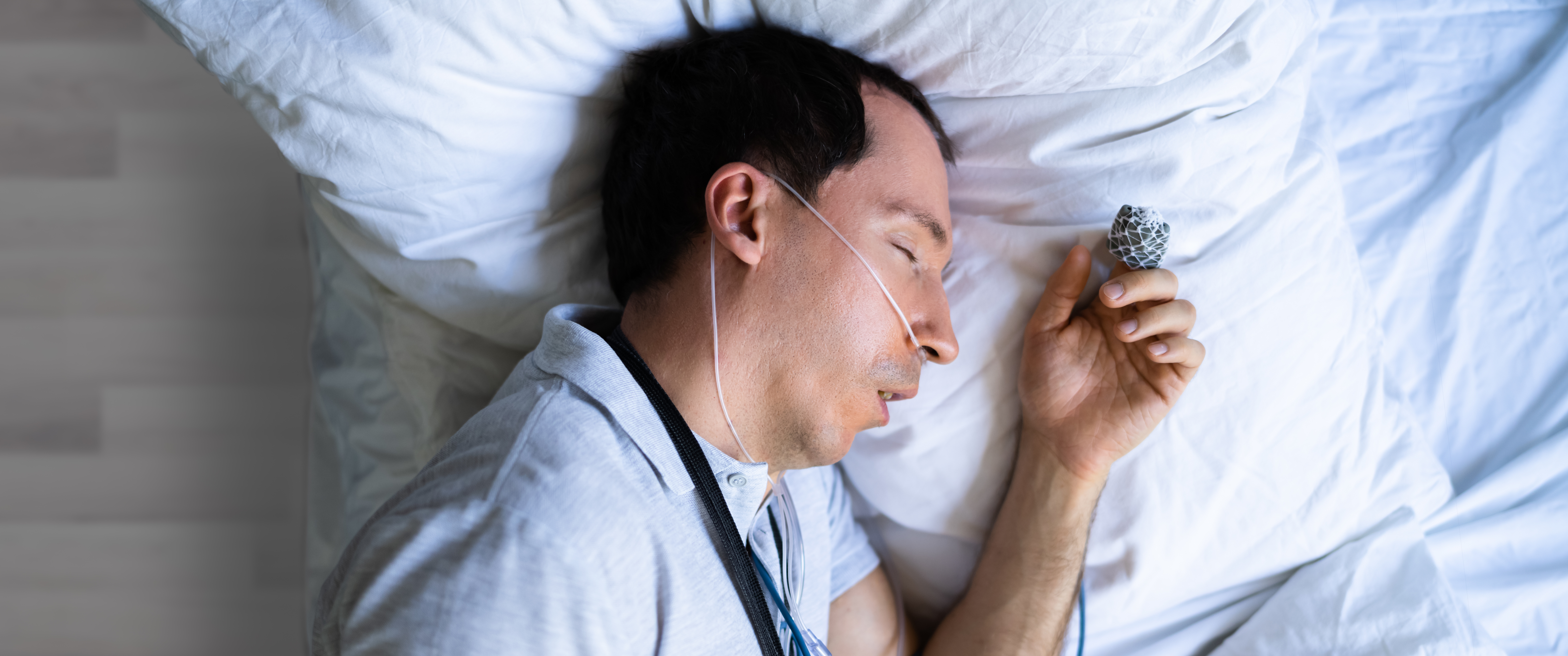 Man sleeping on a bed with devices attached to his body