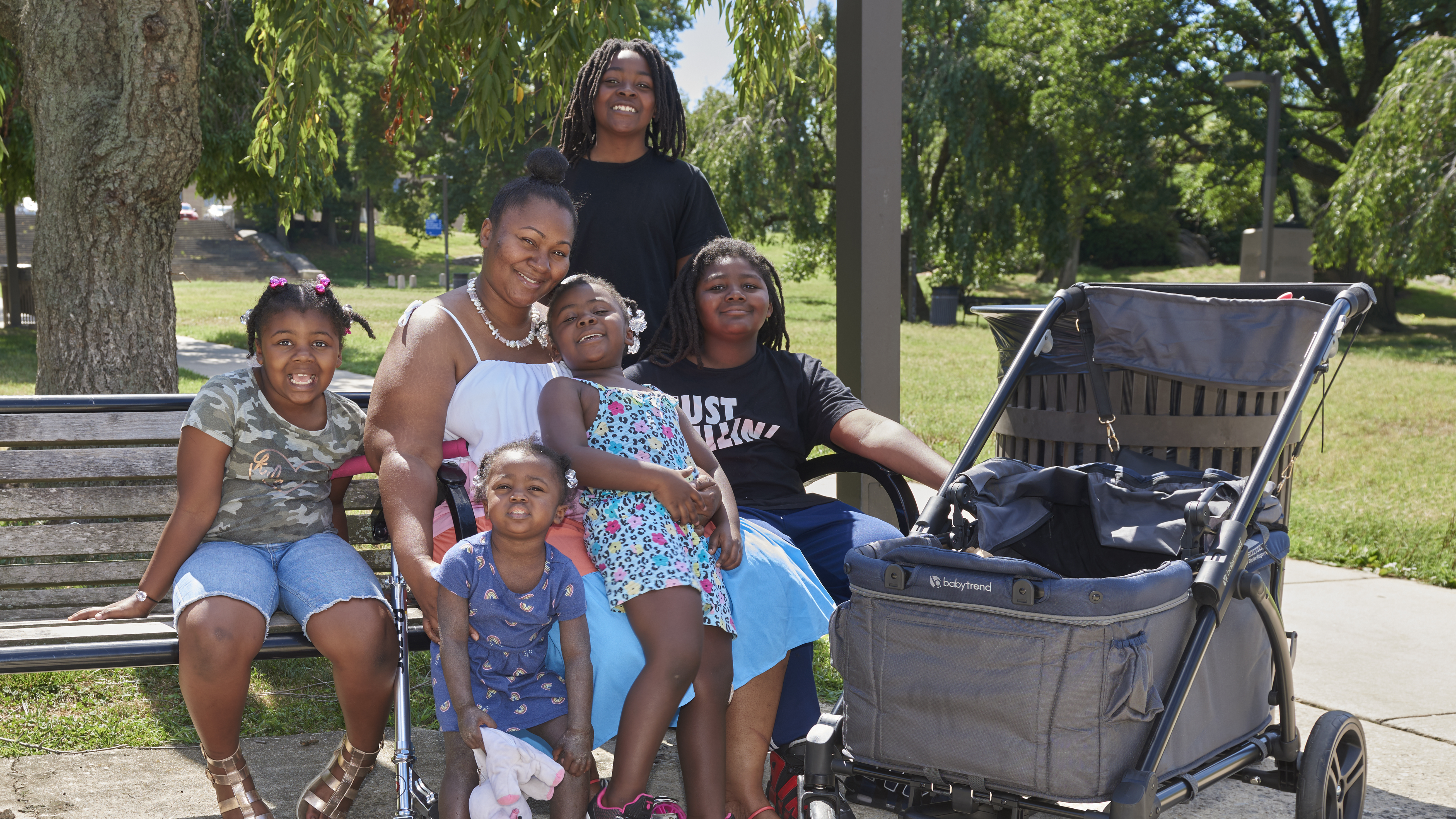  Jean Sanderlin smiling on a park bench surrounded by her five children, ranging from toddler age to about 11
