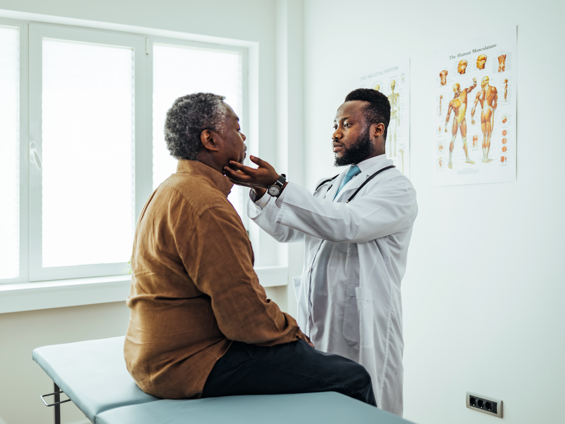 Male doctor palpating patients submandibular lymph nodes