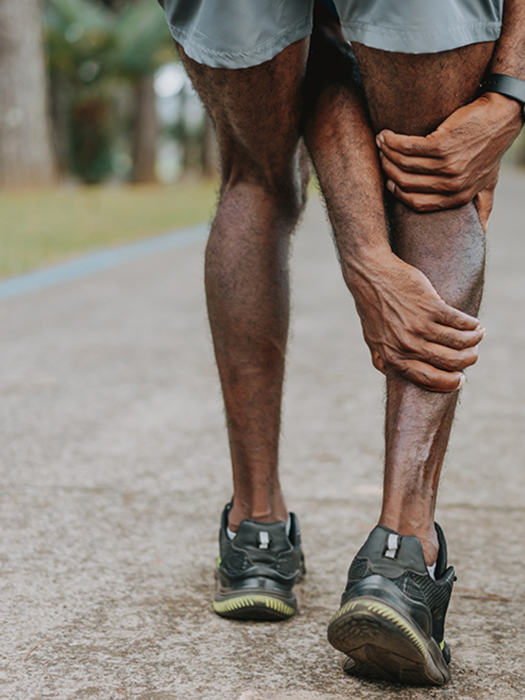 An elderly African-American man clutches his calf in pain