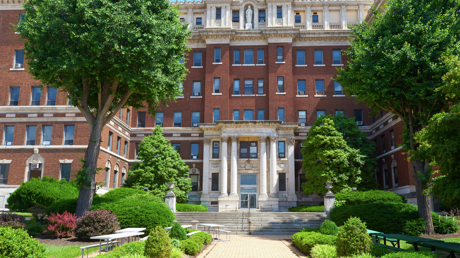 Exterior of the HUP-Cedar hospital building, brick with marble statuary and columns at the top