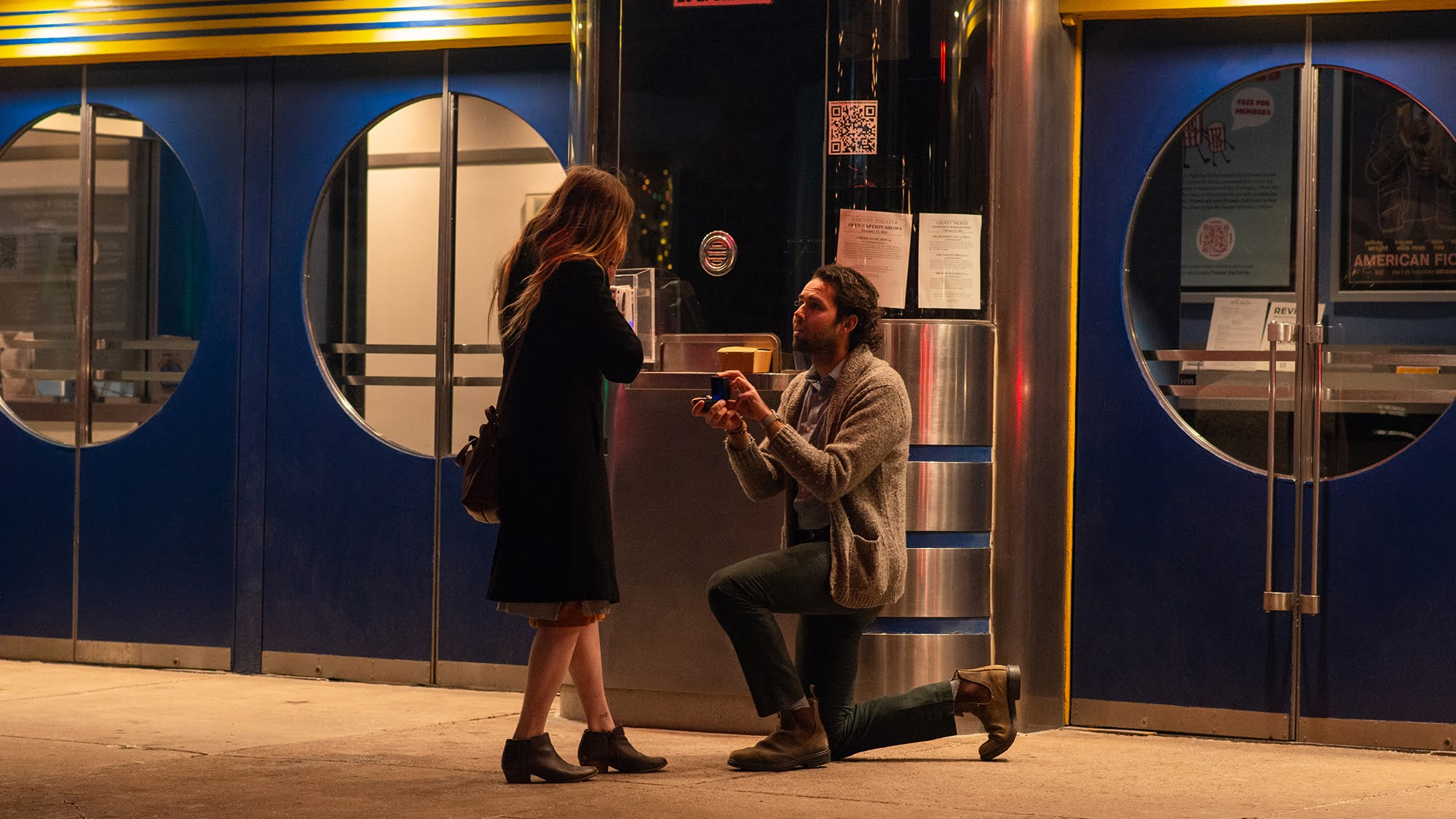 Chris Baccash, on one knee, proposes to his girlfriend