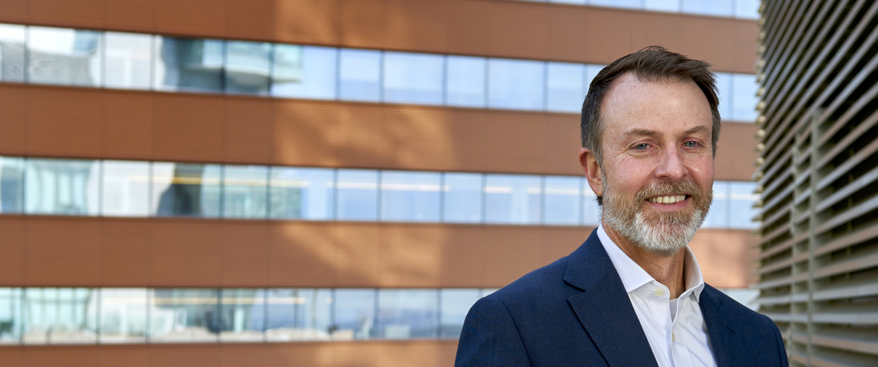 E. John Wherry, PhD, standing in business attire smiling