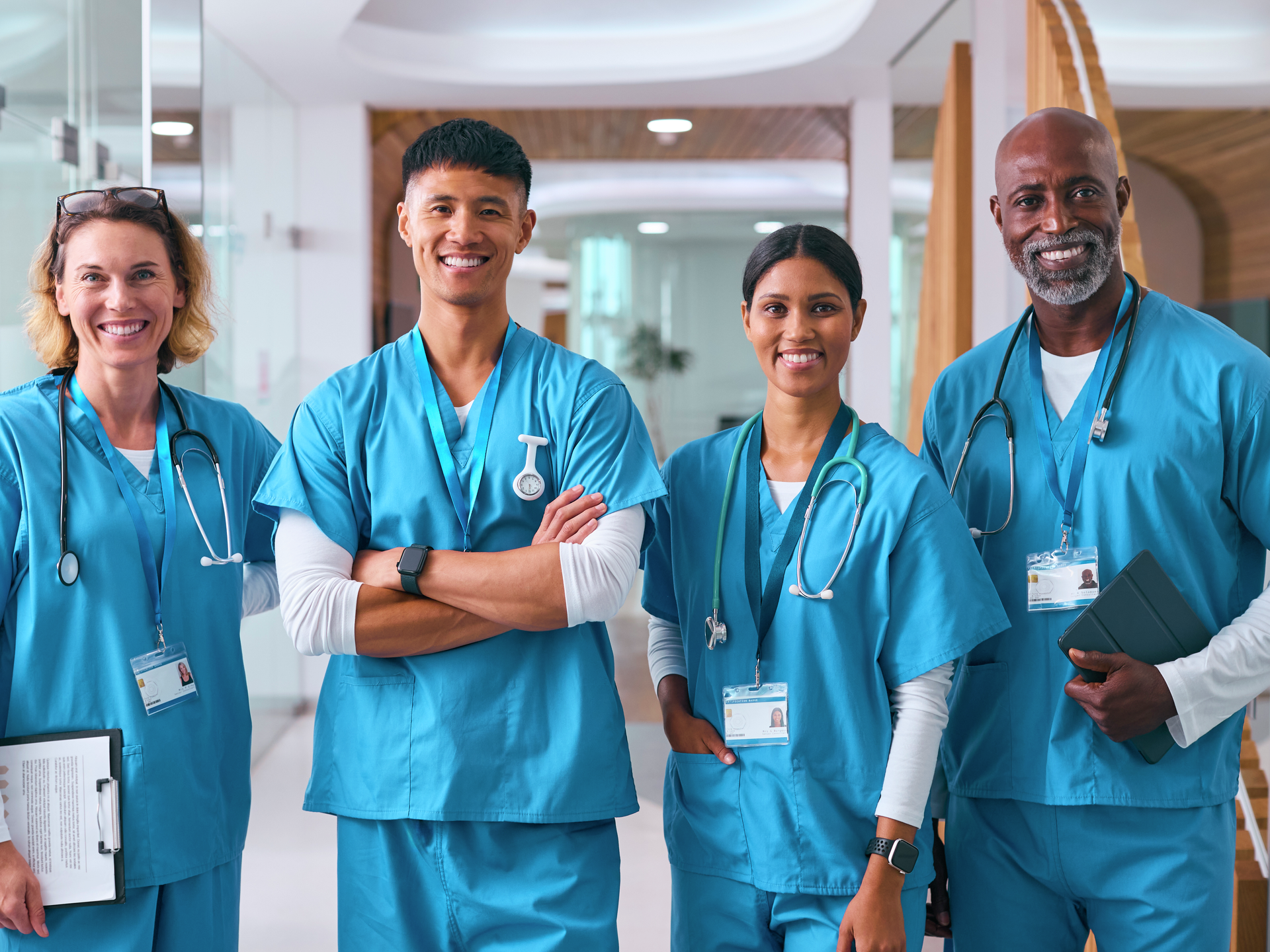 A group of nurses smile in hospital hallway