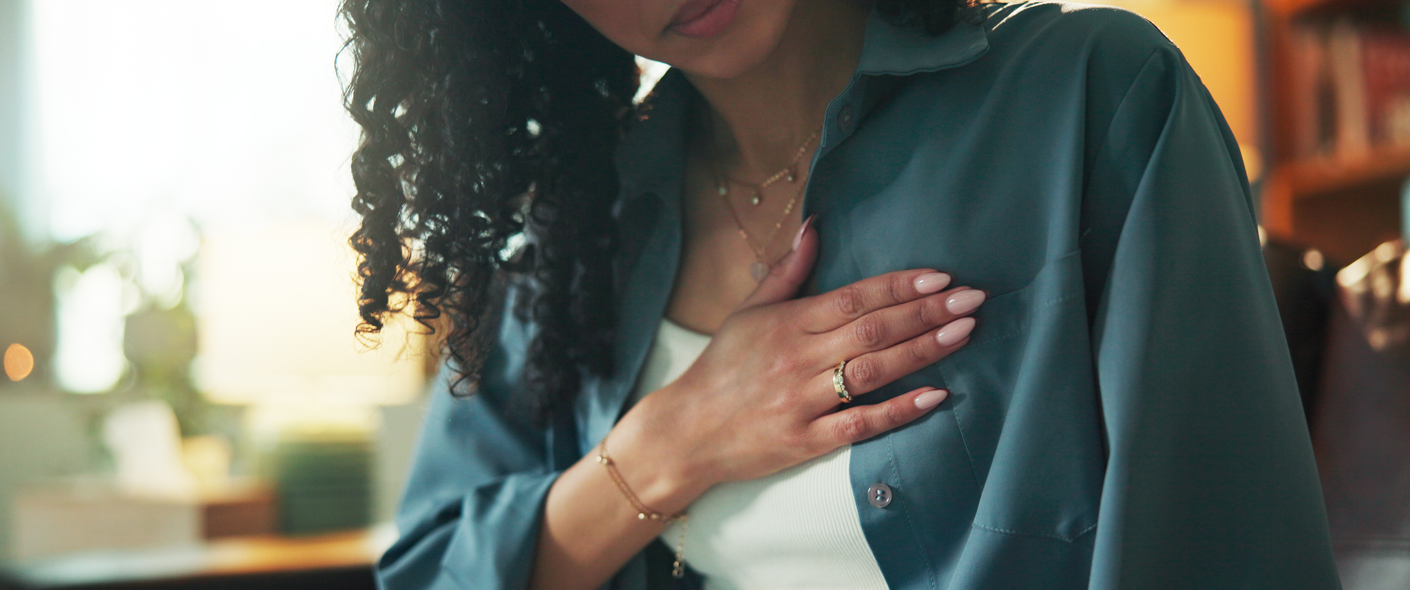 A woman holding her hand to her chest to indicate heart pain.