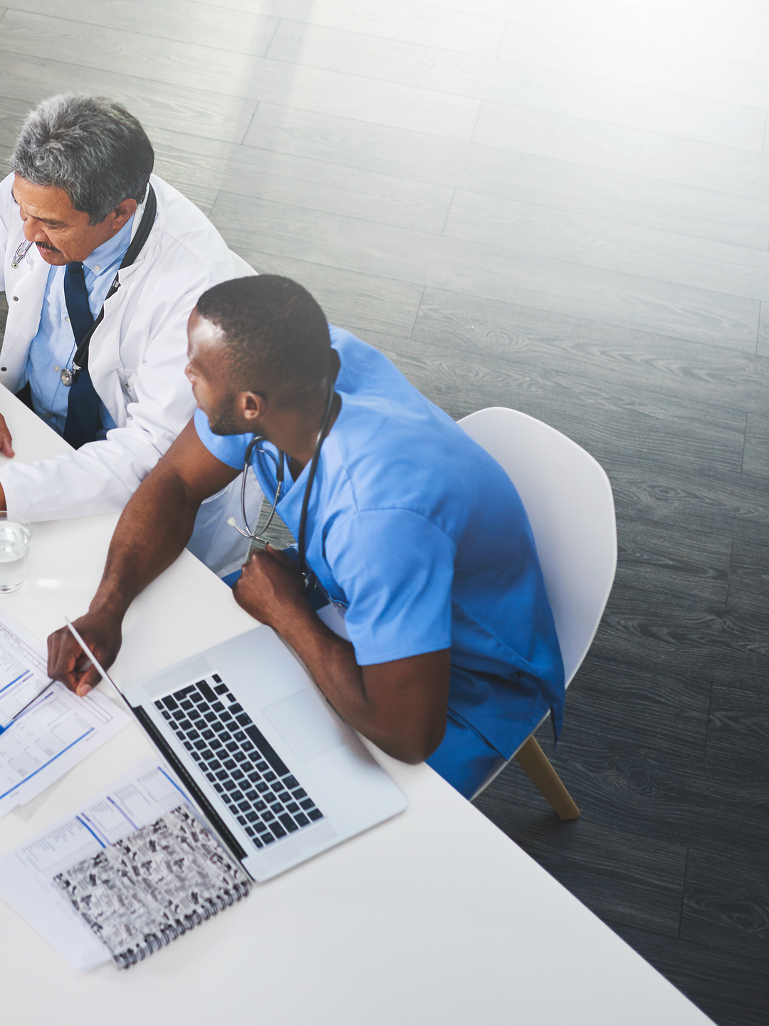 An overhead shot of doctors and nurses sitting at a table working and looking at charts