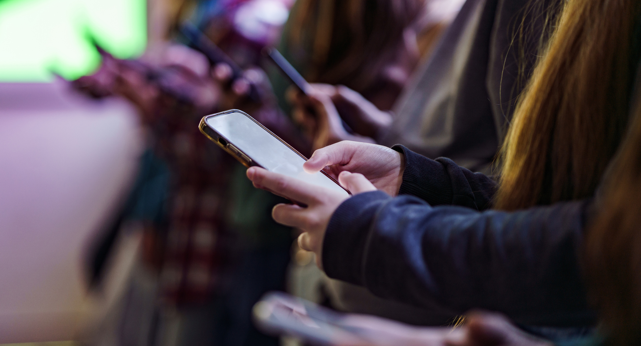 Several children holding cell phones.