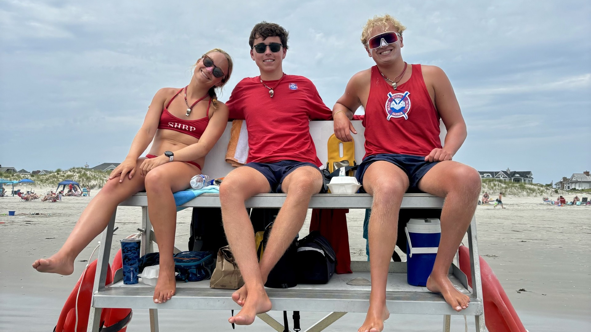 Lifeguards sitting on a lifeguard stand at a beach