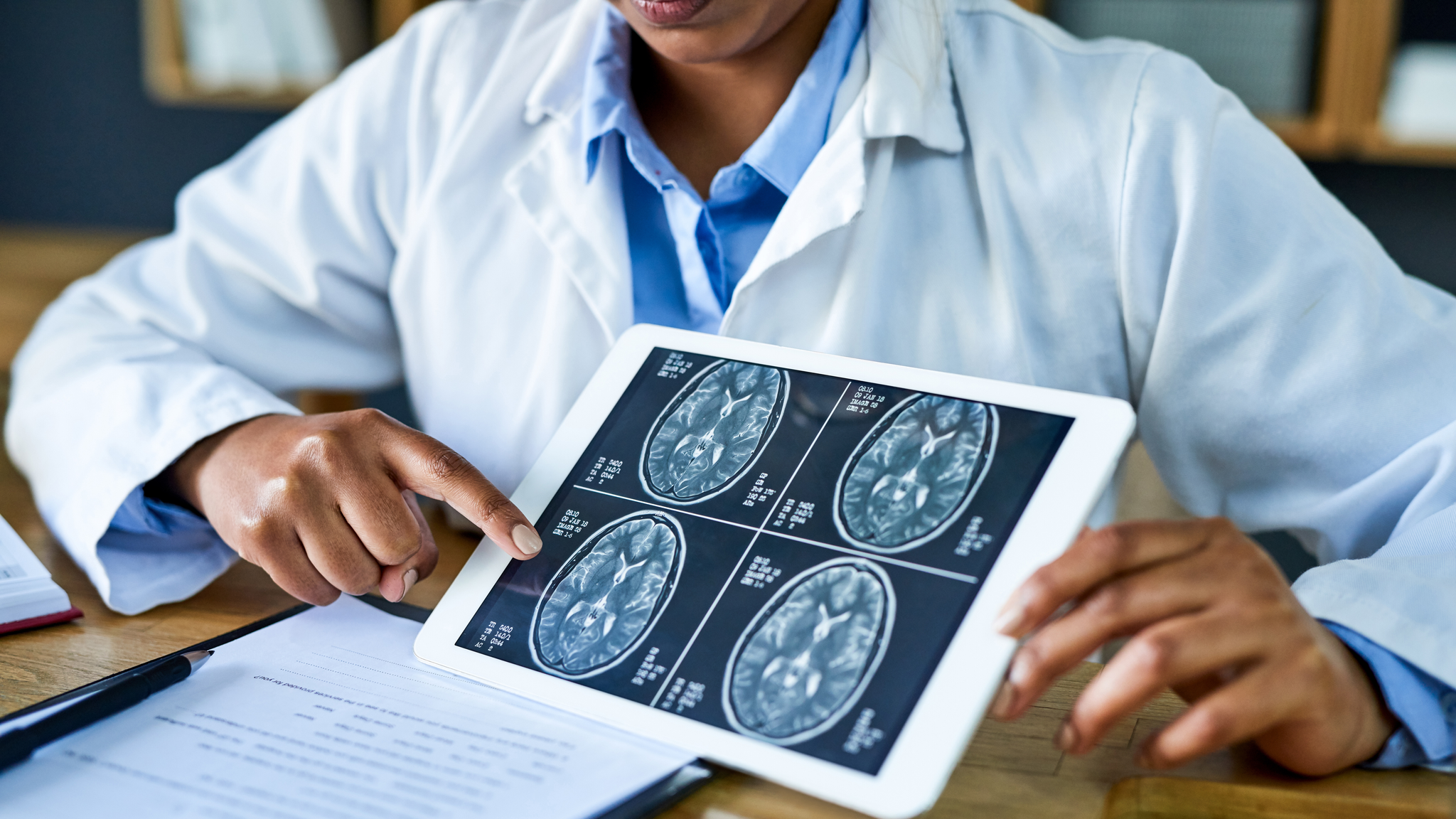 Doctor using a digital tablet to discuss a brain scan during a consultation in her office
