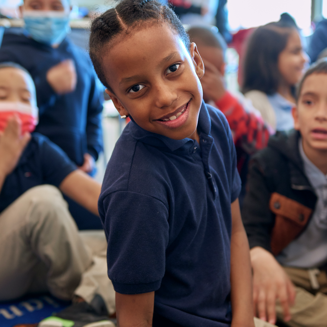 A boy looks confidently at the camera